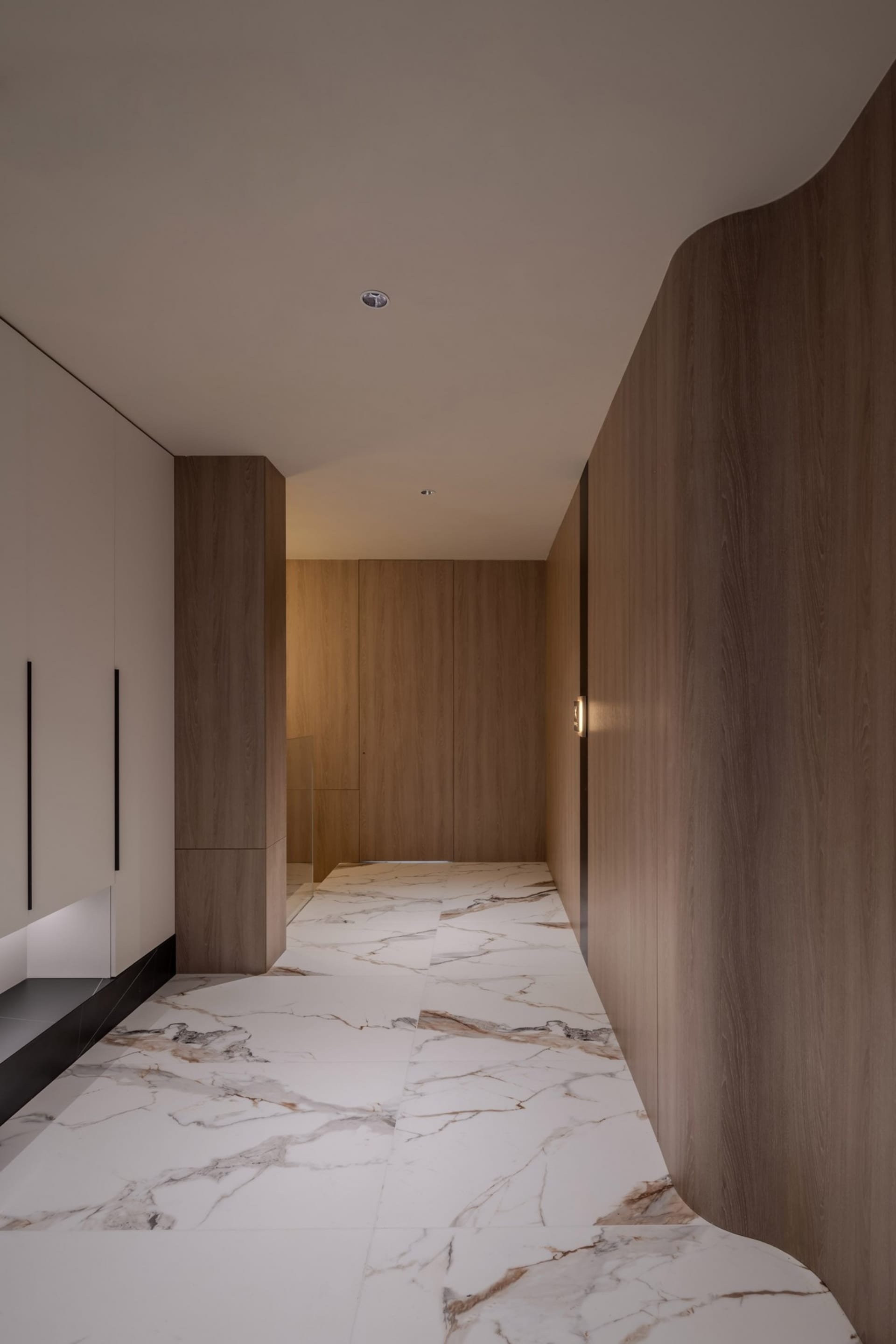 Modern, minimalist corridor with marble floor and wooden walls, featuring elegant lighting and clean lines.