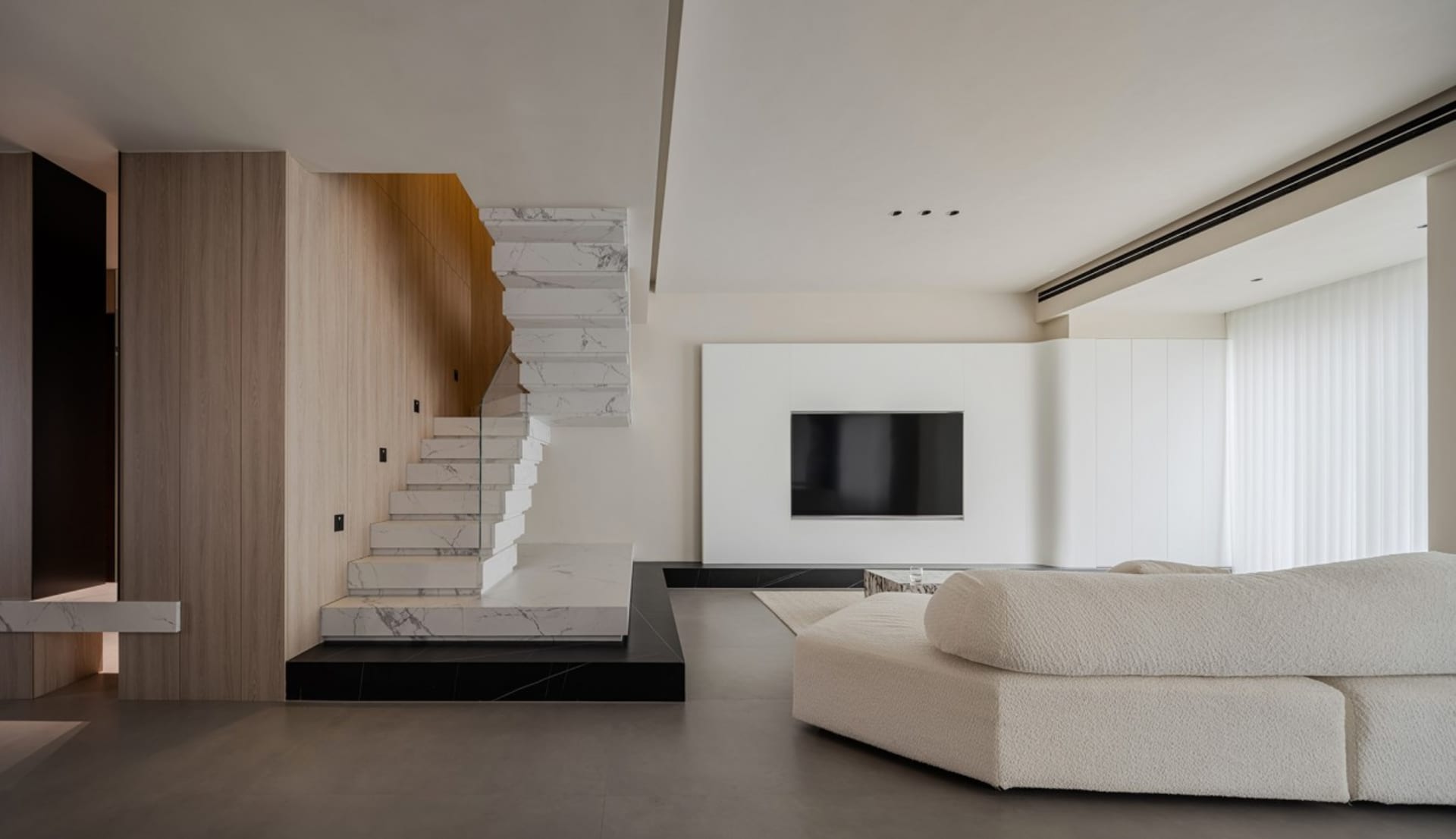 A modern living room featuring marble-clad furniture and minimalist decor.