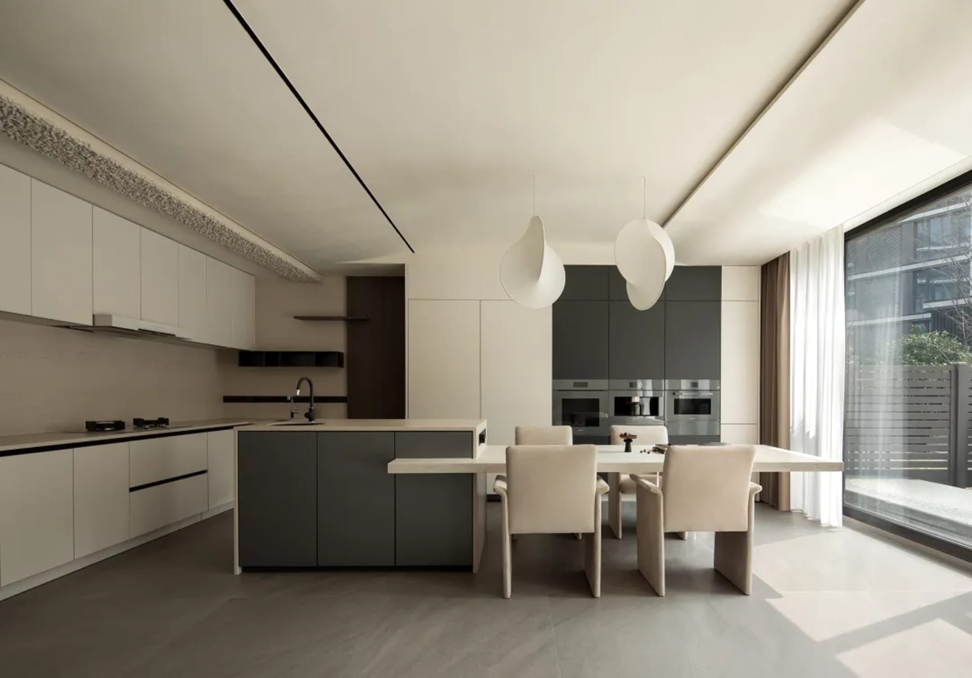 A modern kitchen with stone countertops, white cabinets, and stainless steel appliances.