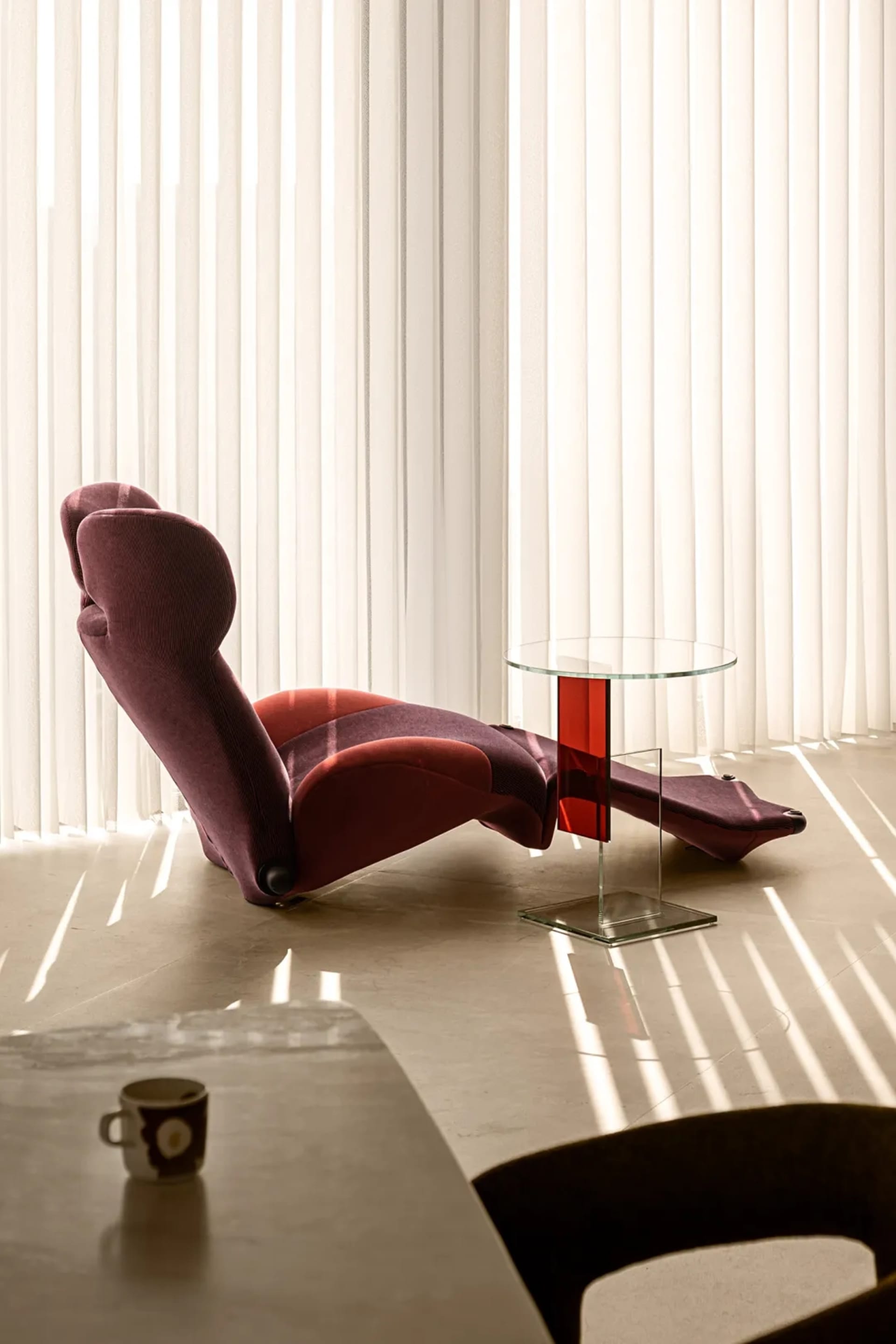 Modern living room with a comfortable lounge chair and glass side table.