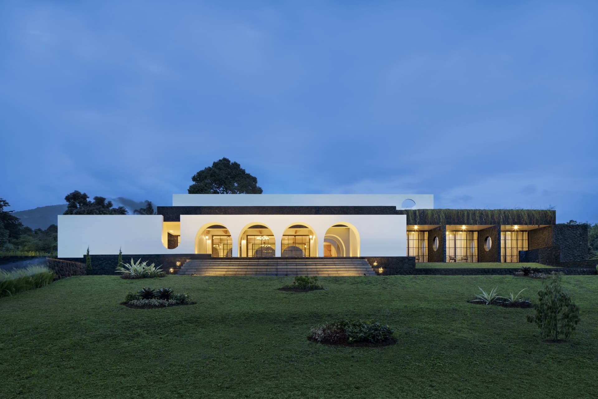 A modern residential house featuring stone, glass, and cement materials.