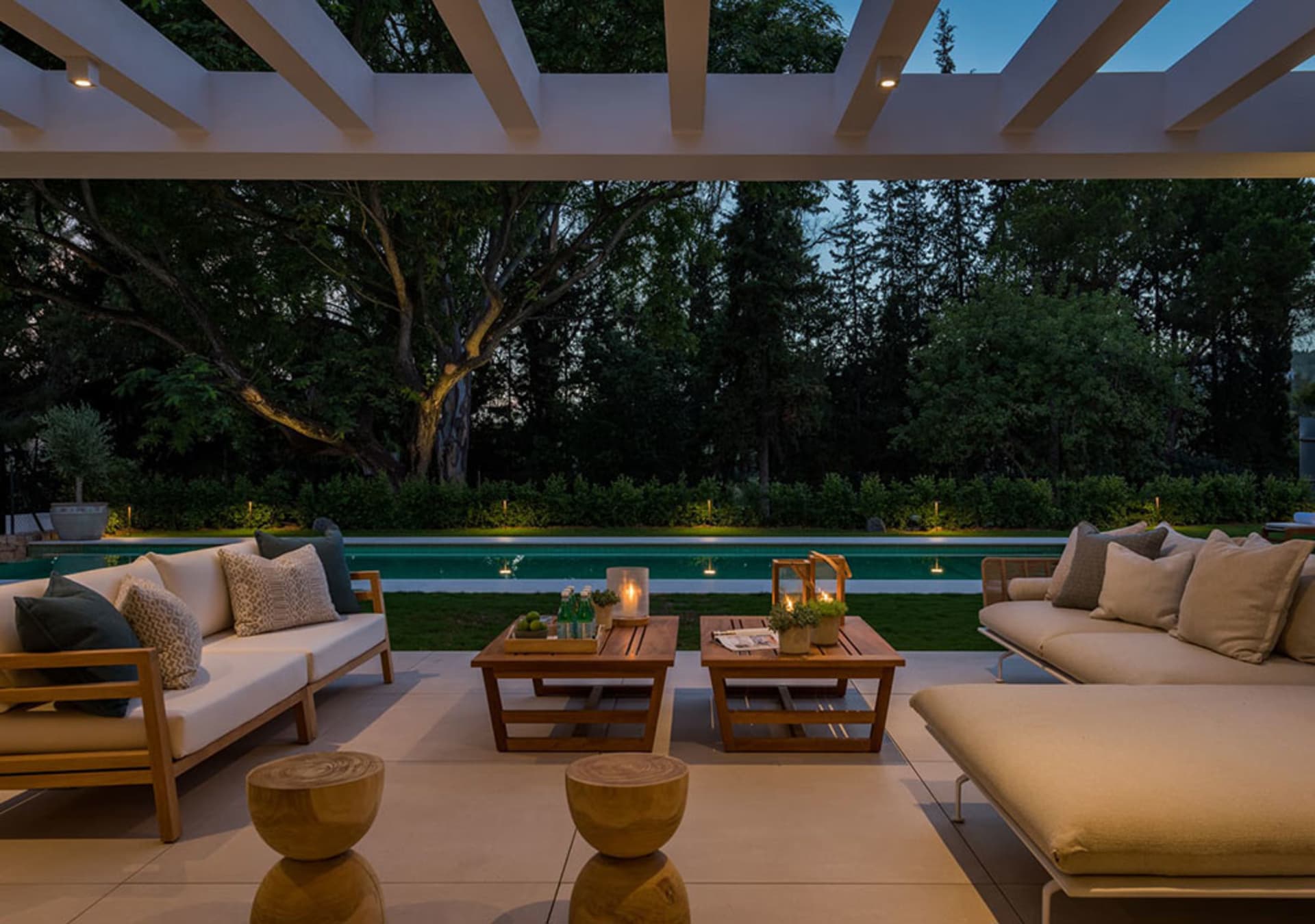 A minimalist patio with wooden furniture and a pergola.