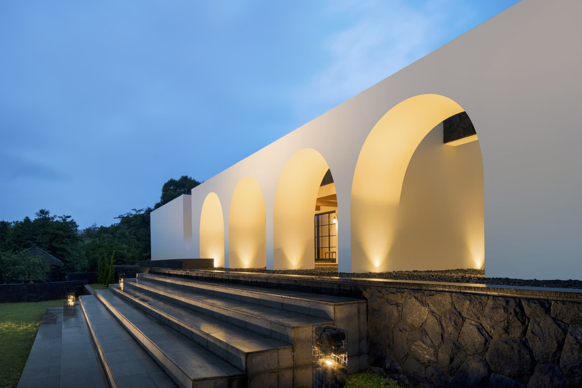 Modern architectural design featuring concrete archways lit from within.