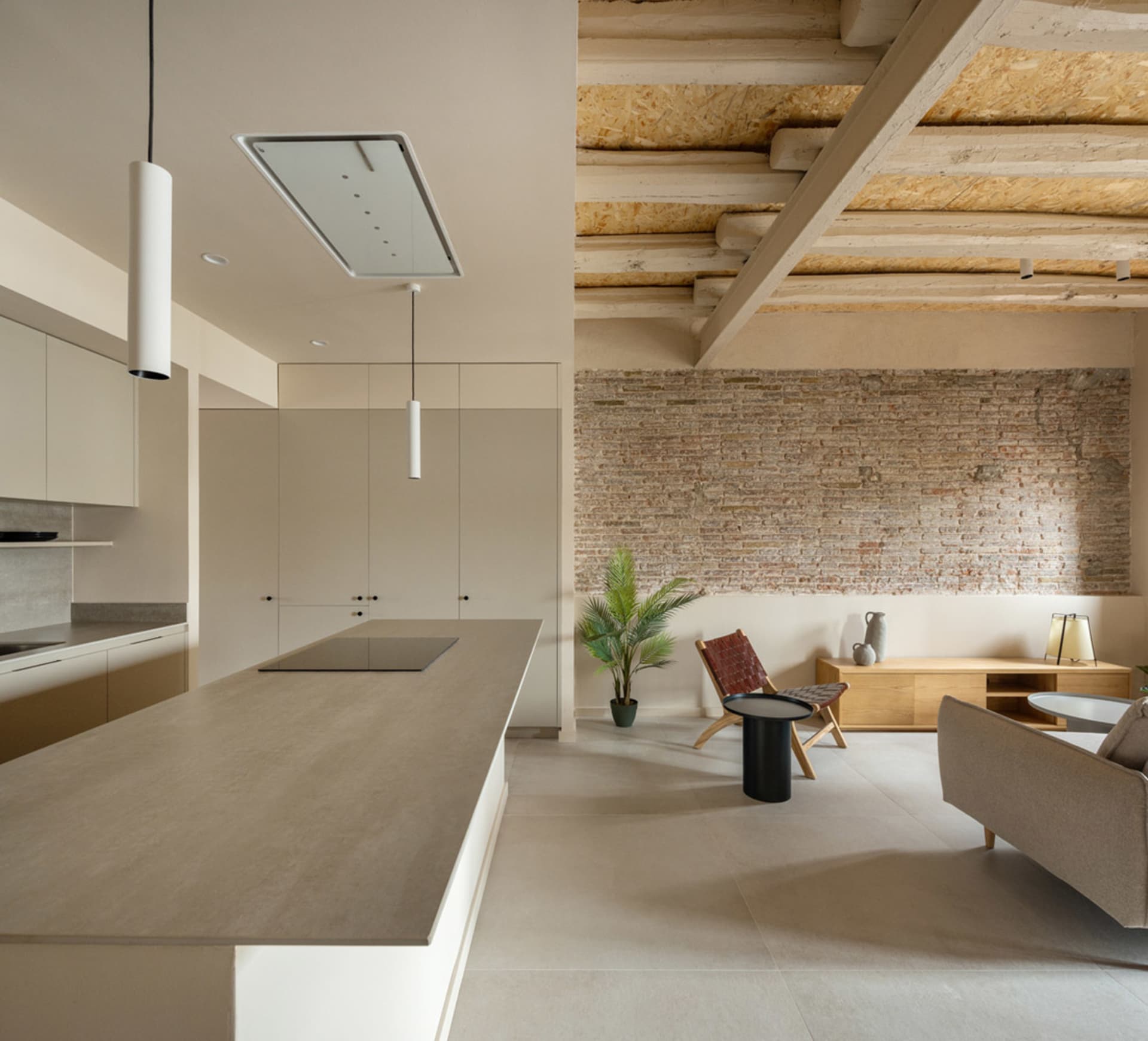 A modern kitchen with minimalist design features concrete countertops and walls.