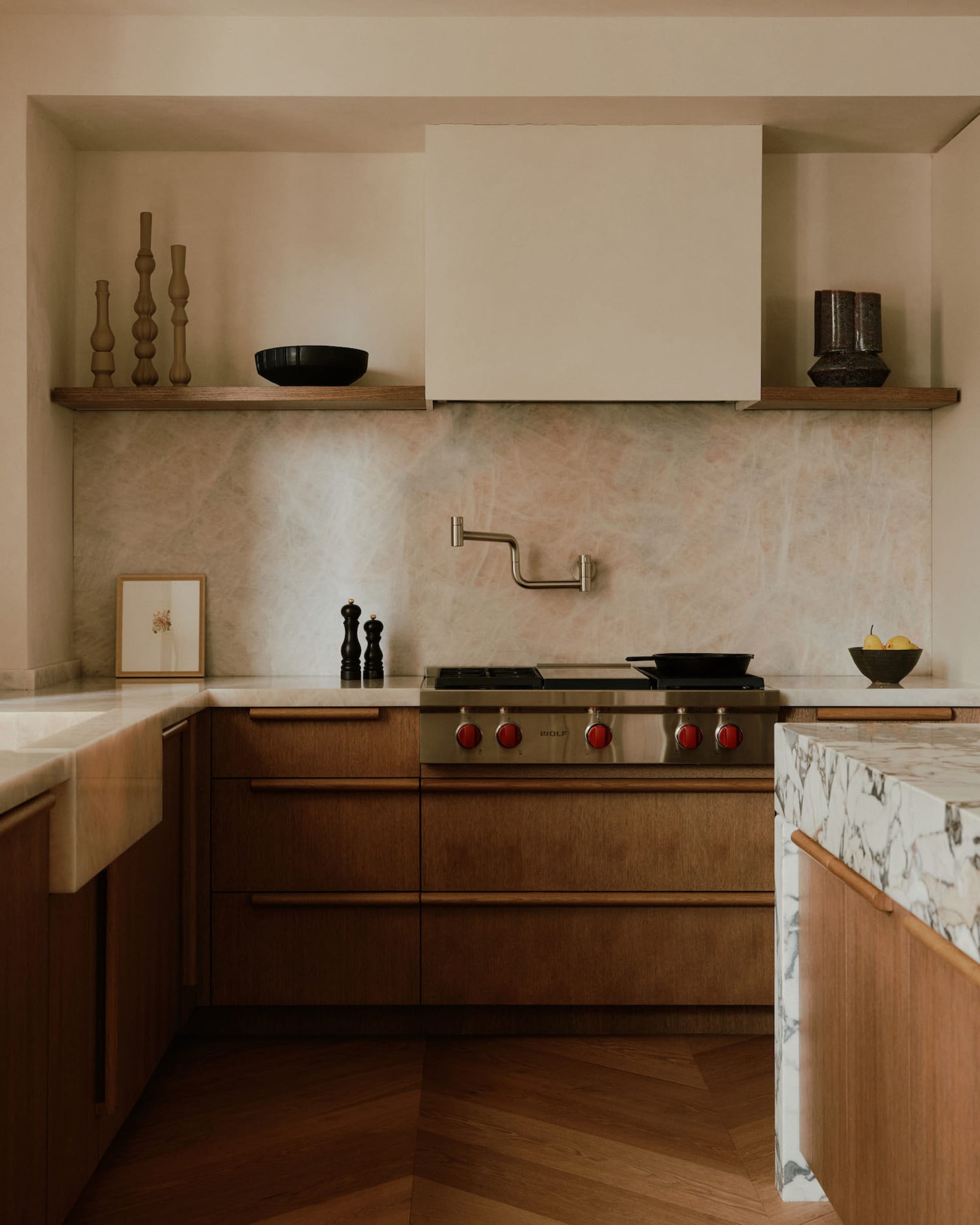 A modern residential kitchen featuring wooden cabinets, a marble countertop, and metal appliances.