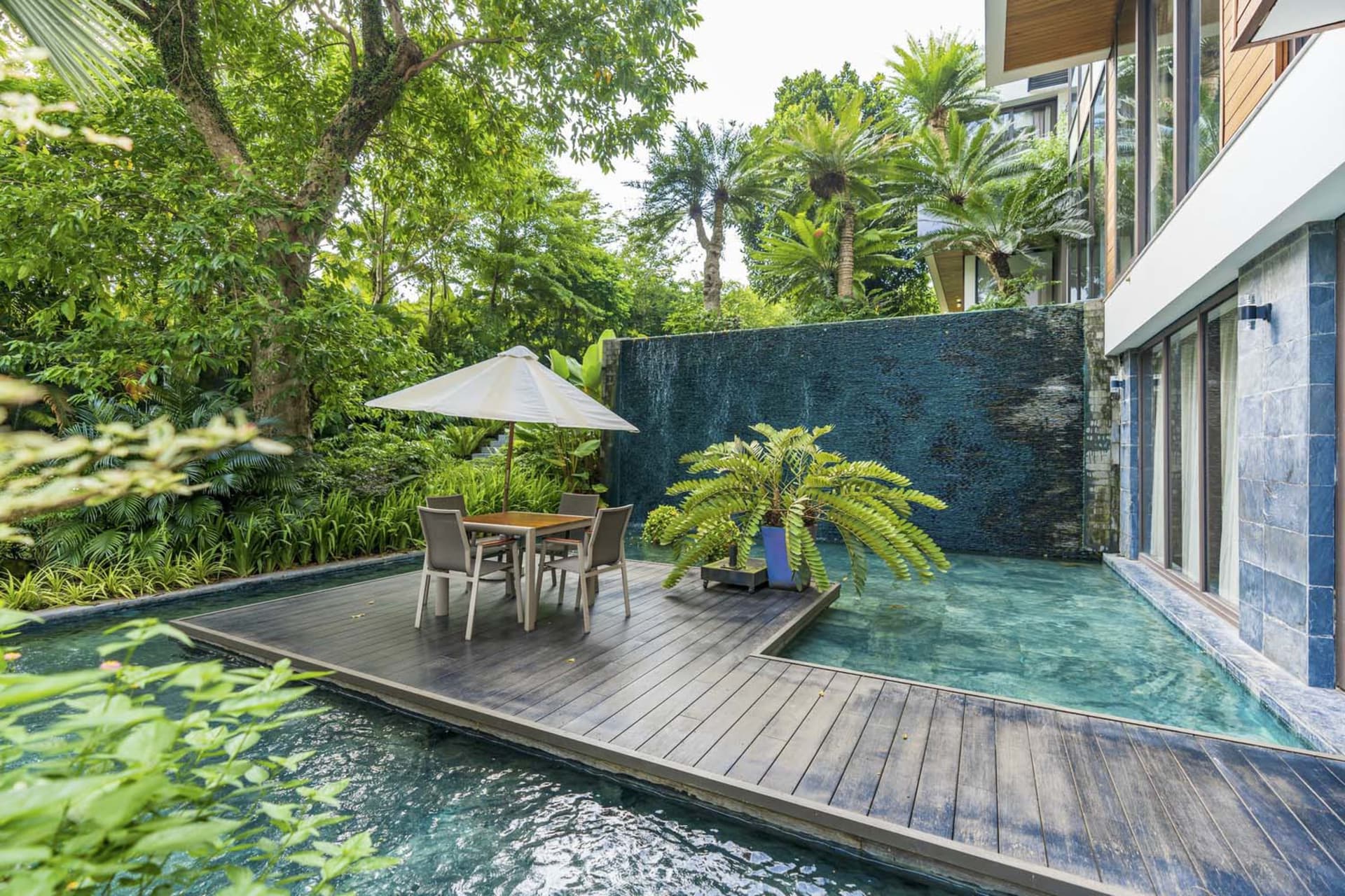 A modern residential pool area featuring wood and concrete materials.