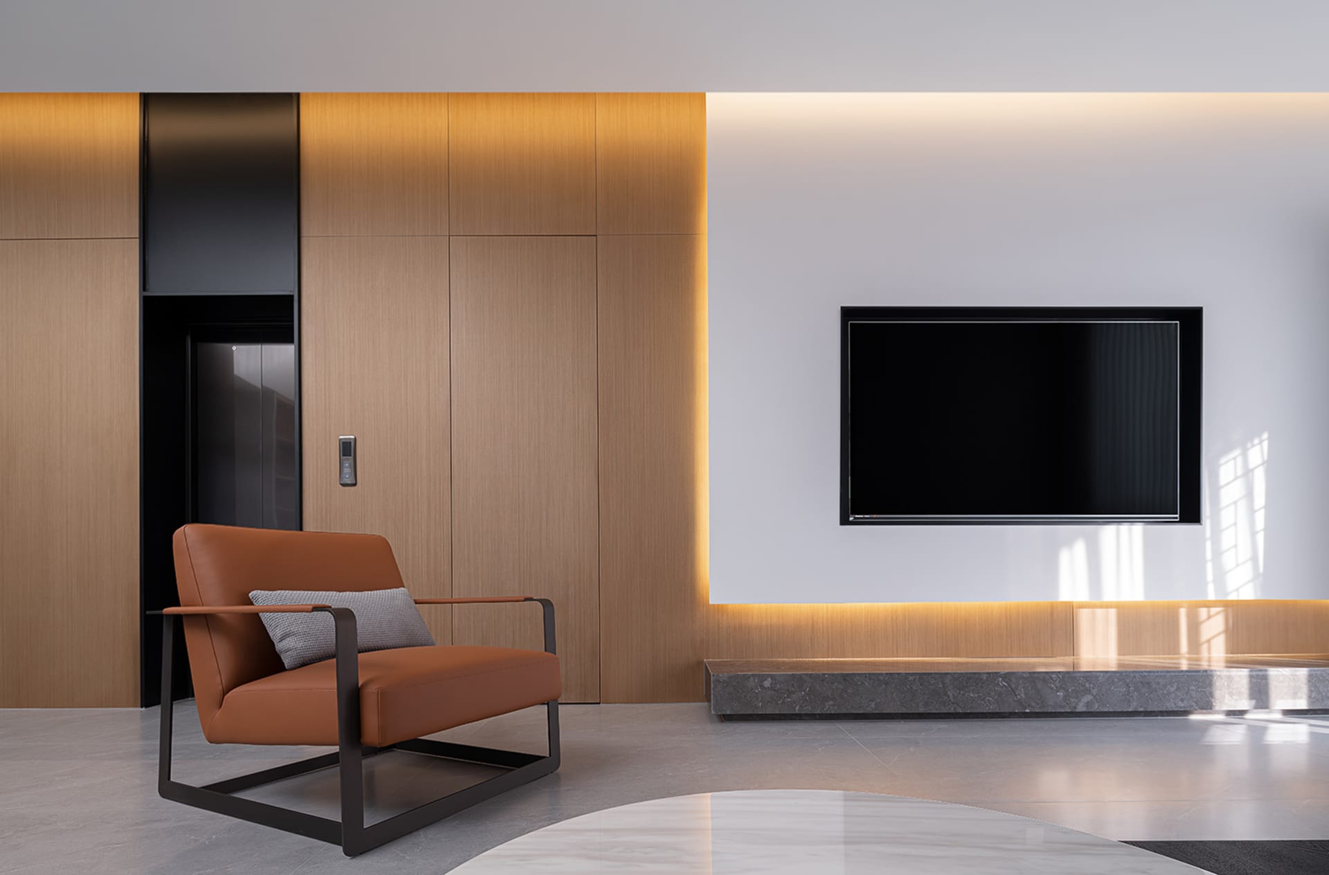Modern living room with a brown leather armchair and wooden cabinets