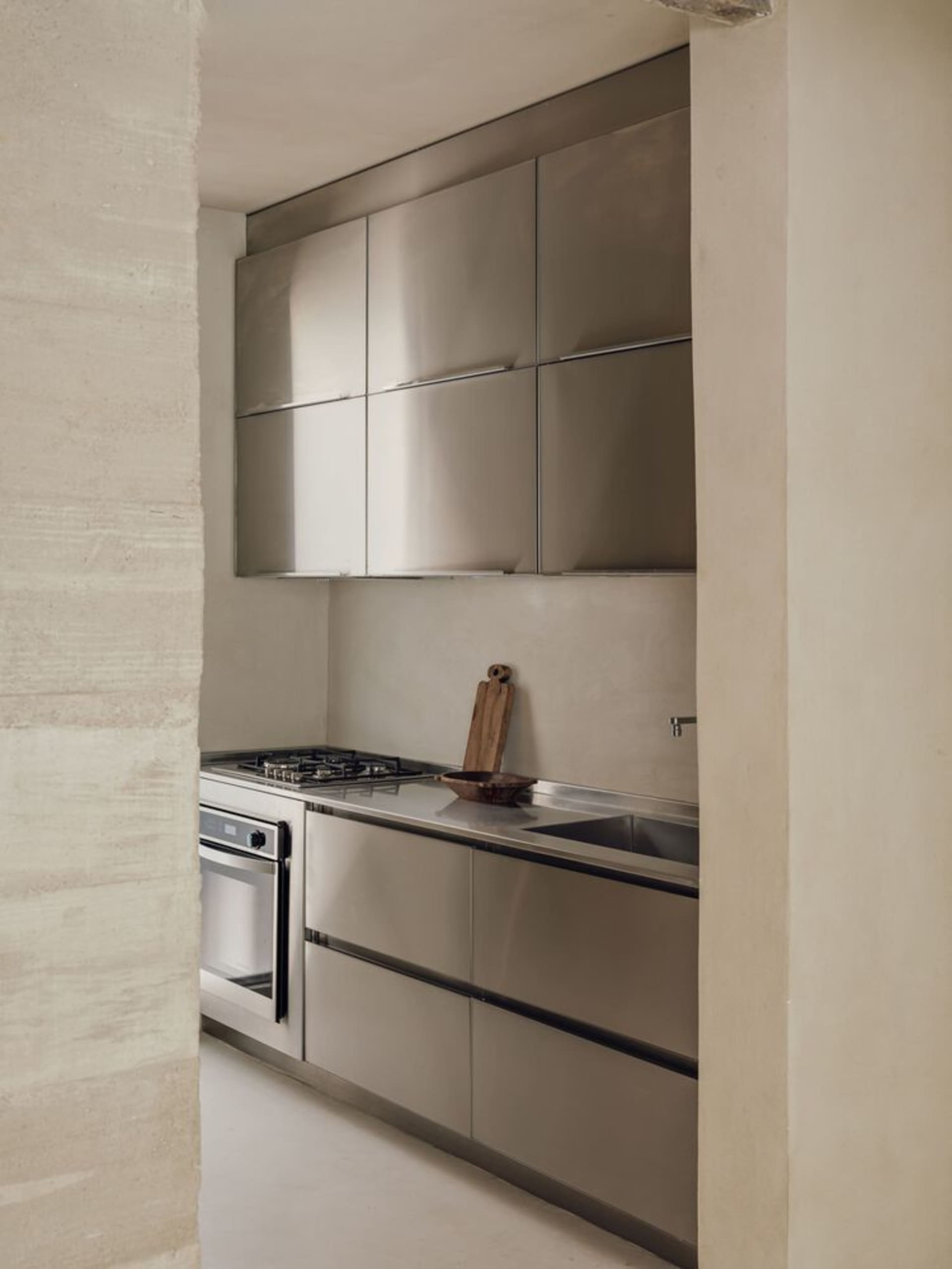 Modern minimalist kitchen with metallic cabinets and stainless steel appliances