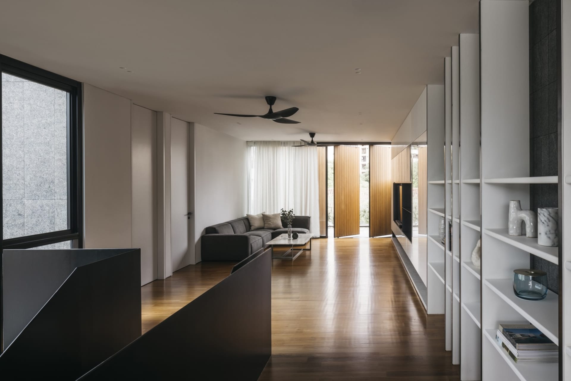 Modern minimalist living room featuring wood flooring and minimalist furniture.