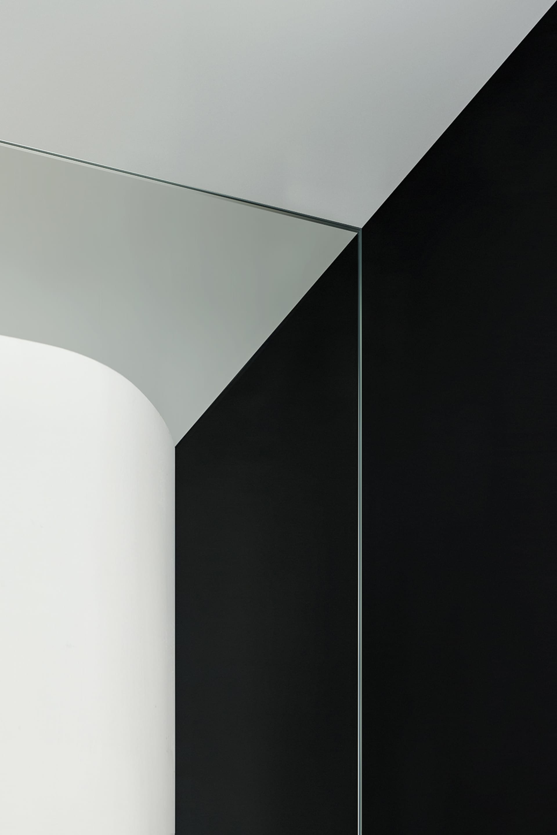 A modern black and white interior space featuring glass architectural elements.