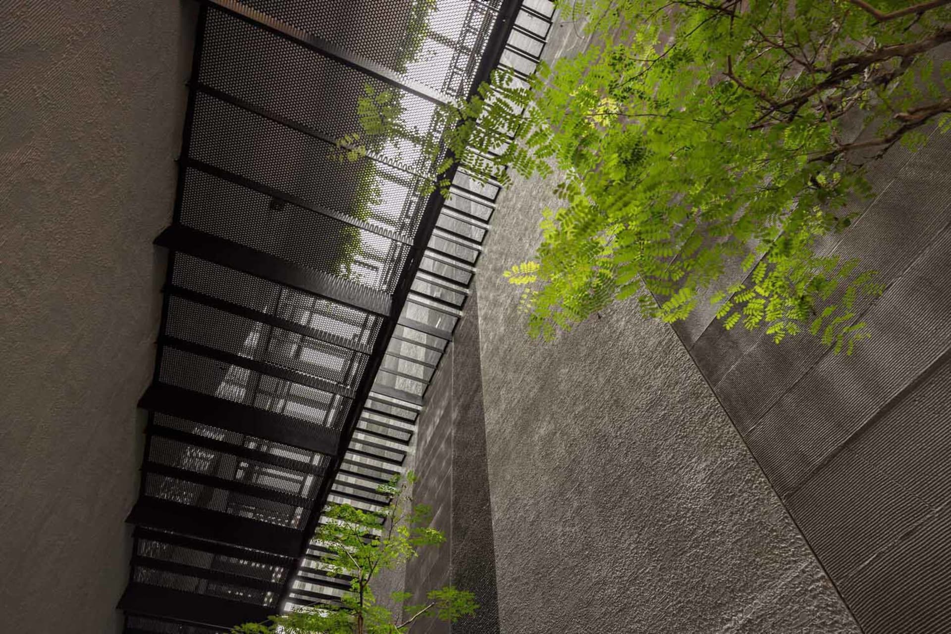 A modern interior space with a concrete wall and metal stairs.