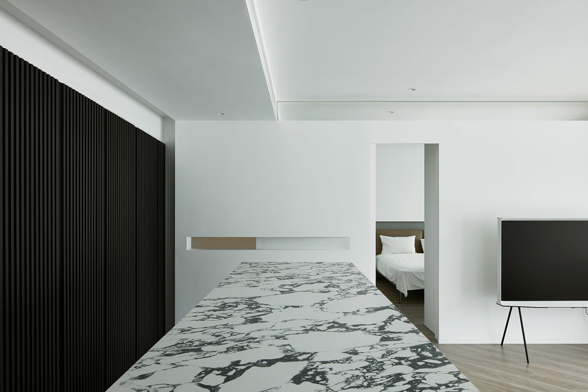 Modern minimalist apartment interior with marble floor and black, white, and gray color scheme.