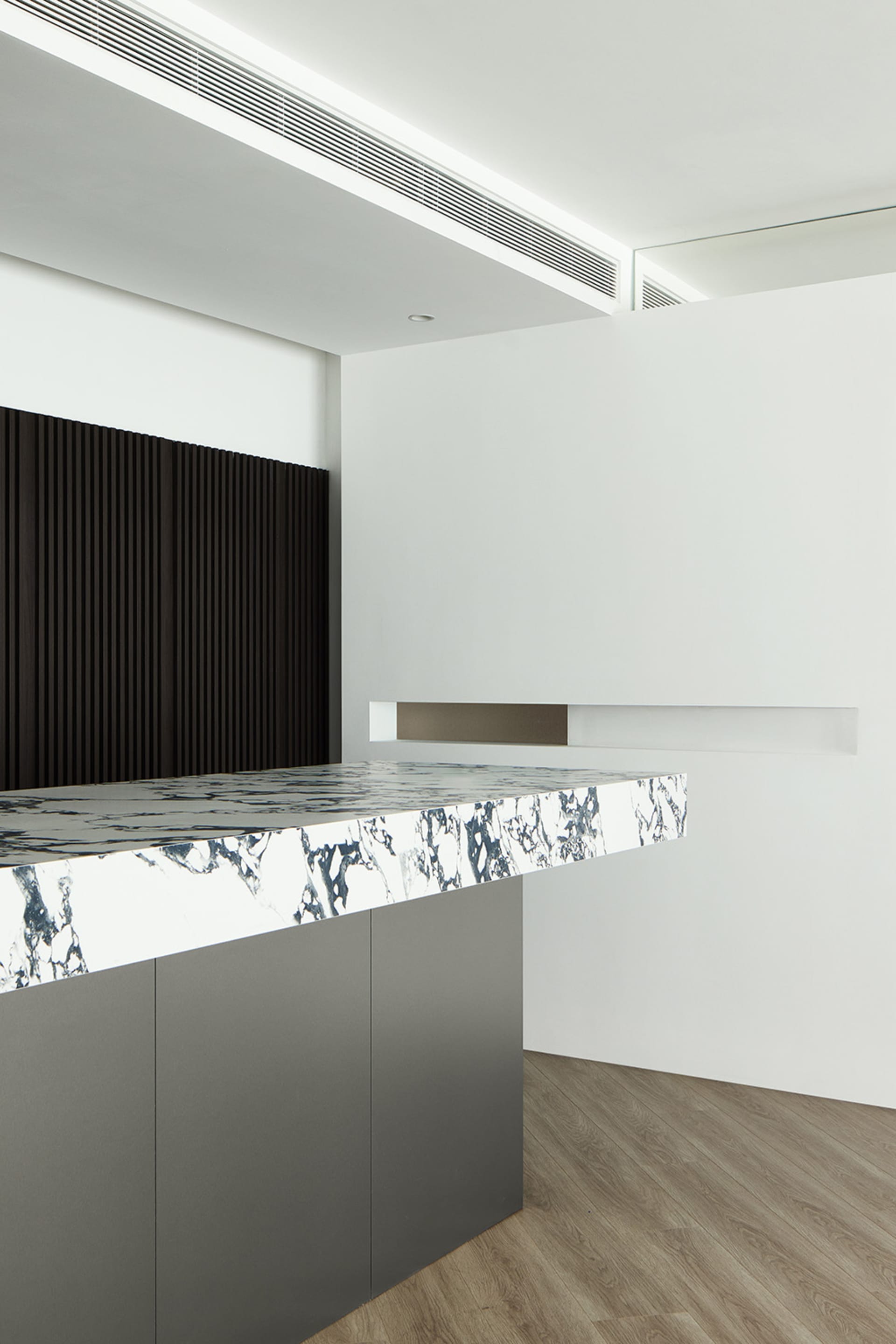Modern office space with a marble countertop and dark wooden accents.