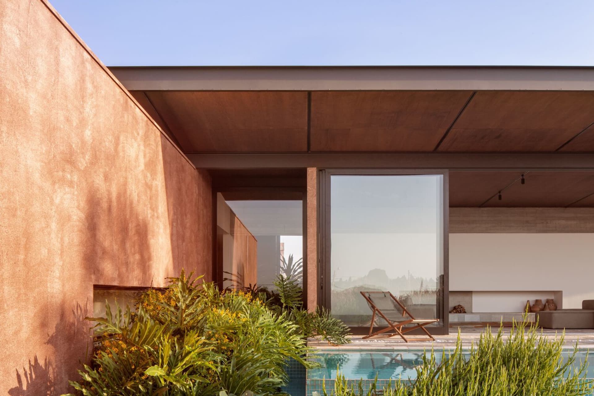 A modern villa with a concrete exterior and a poolside area.