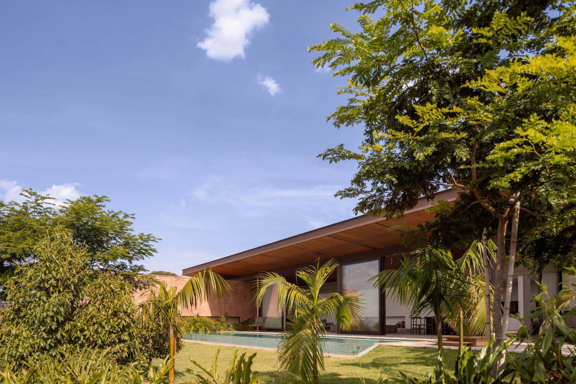 Modern residential exterior featuring concrete, glass, and wooden elements.