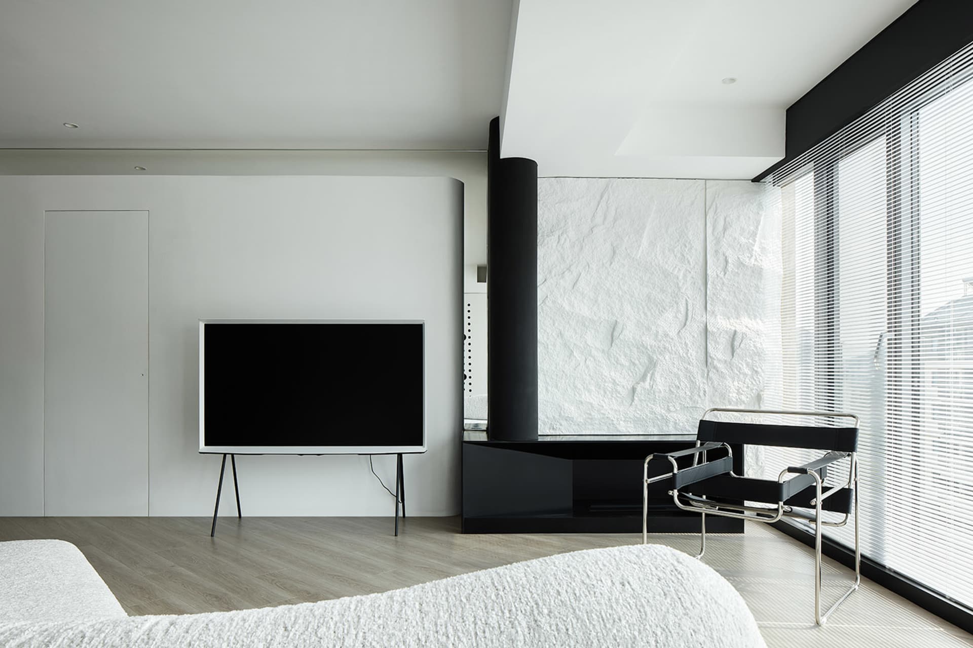 Modern minimalist bedroom featuring white walls and furniture.