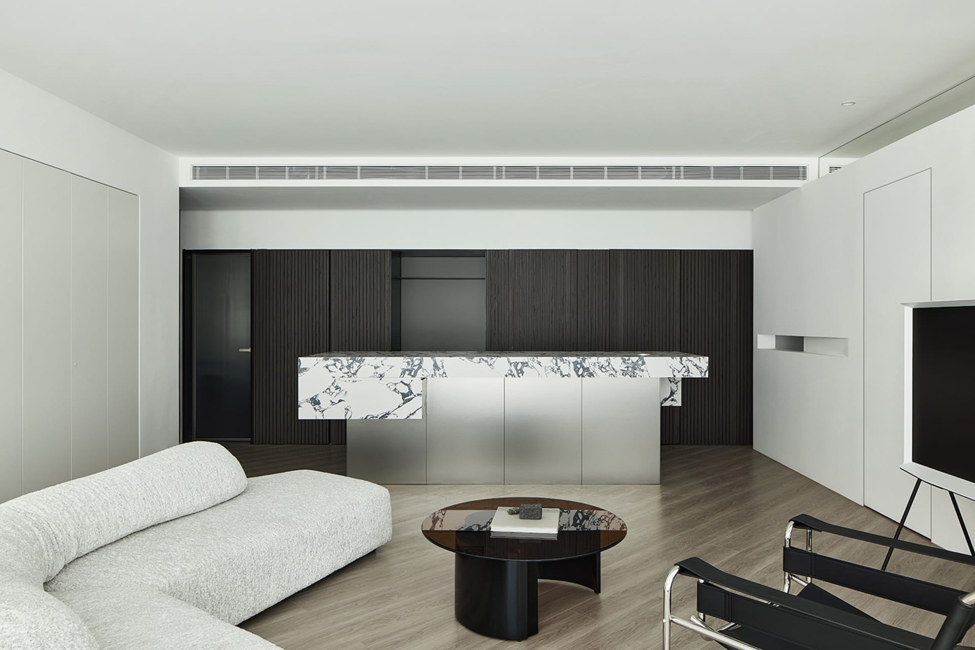 Modern living room featuring marble, stainless steel, and wood elements.