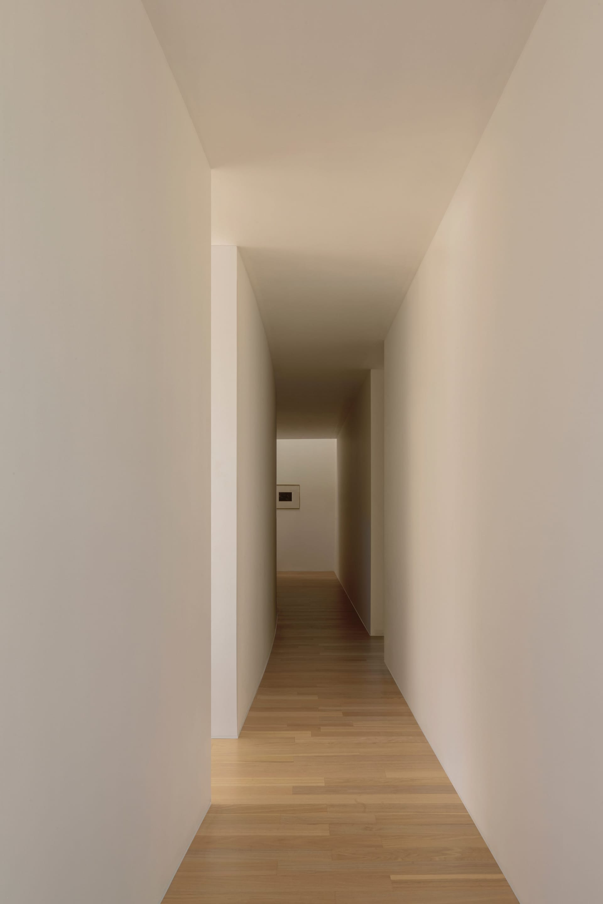 A minimalist corridor with wooden flooring, highlighting clean lines and light tones.