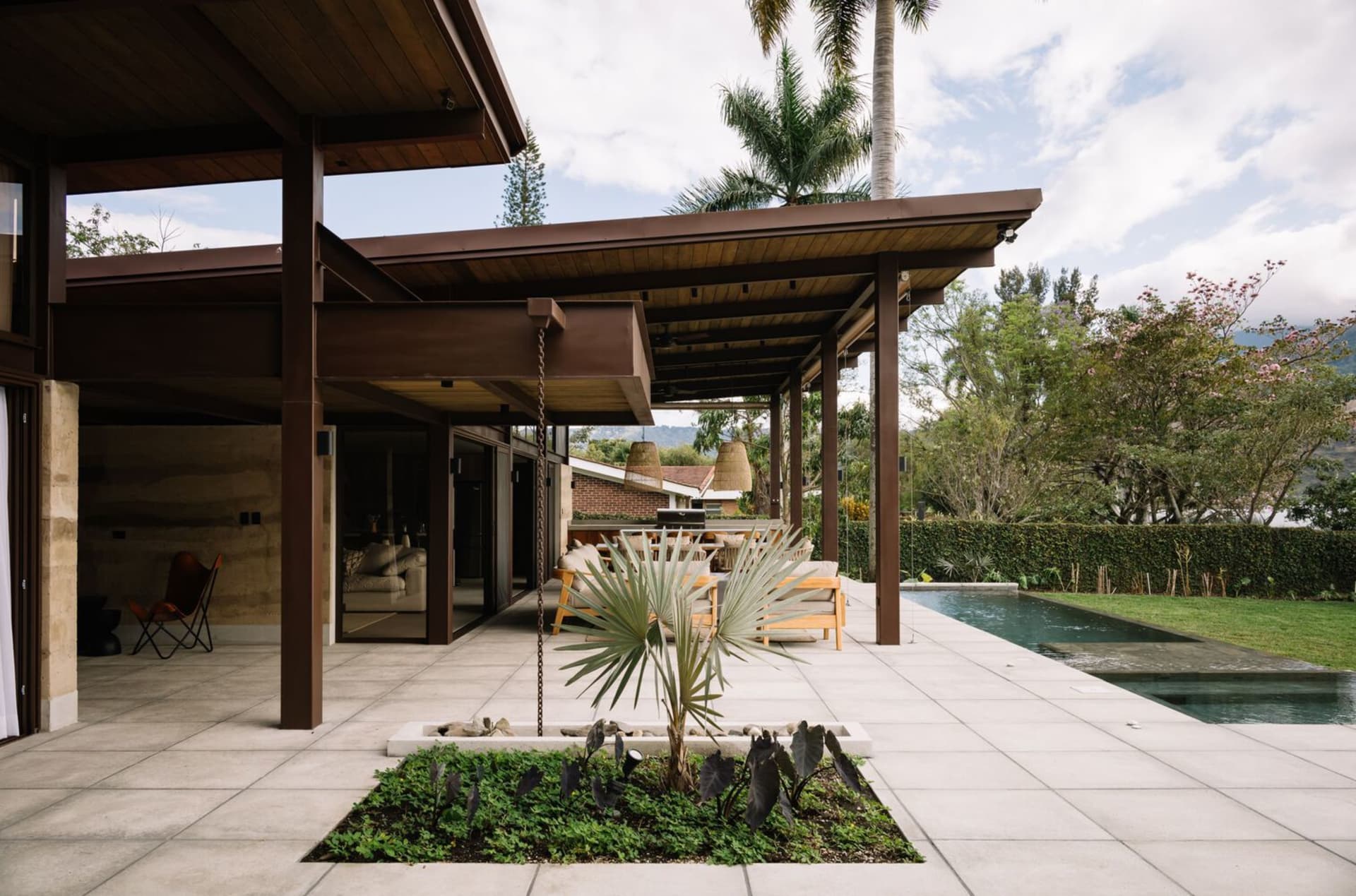 A modern residential exterior featuring concrete, wood, and glass materials.