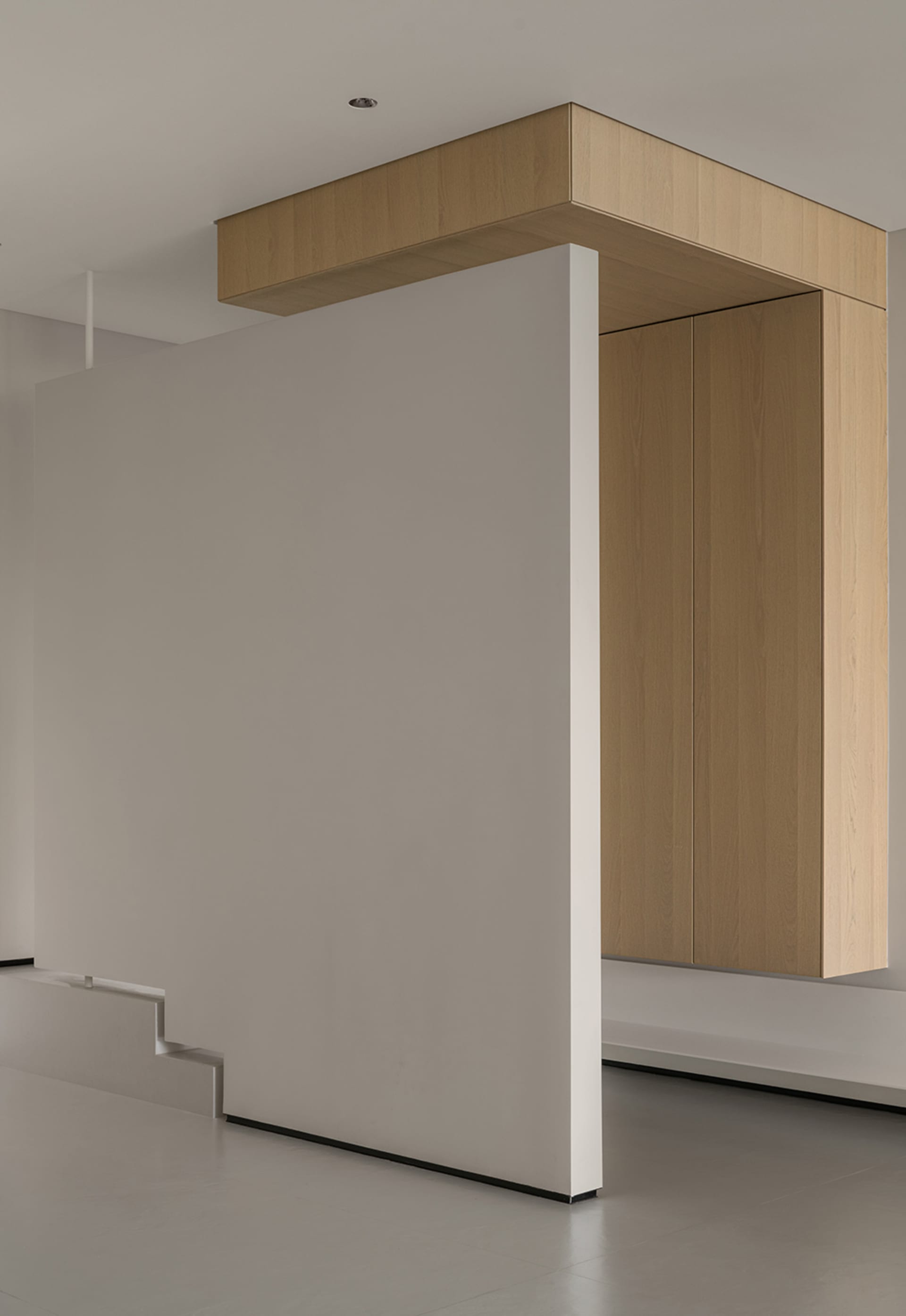 Modern minimalist interior featuring wooden furniture, concrete flooring, and white walls.