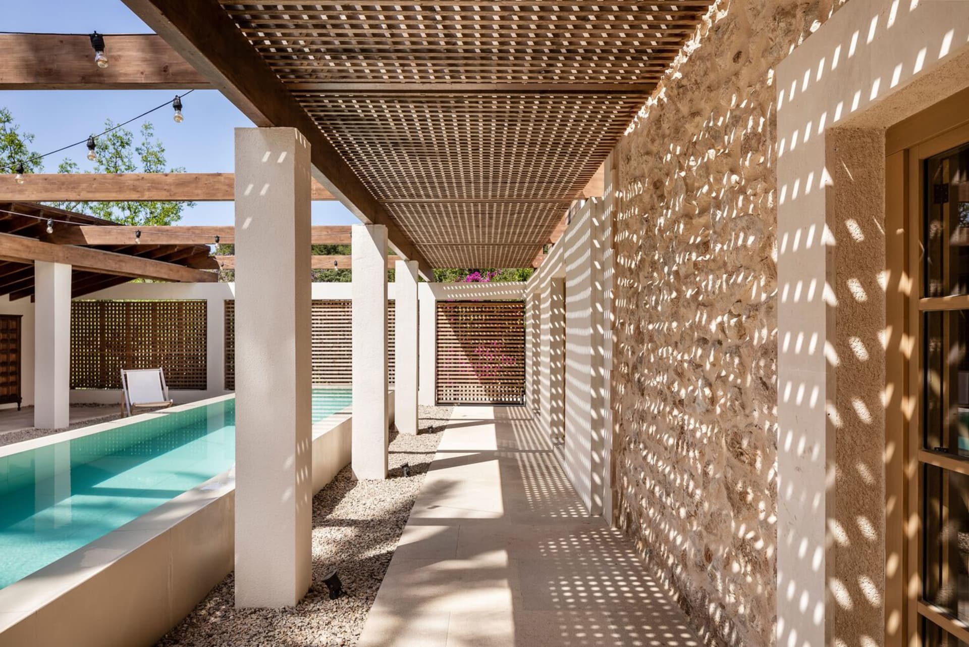 A modern poolside veranda featuring stone and concrete materials.