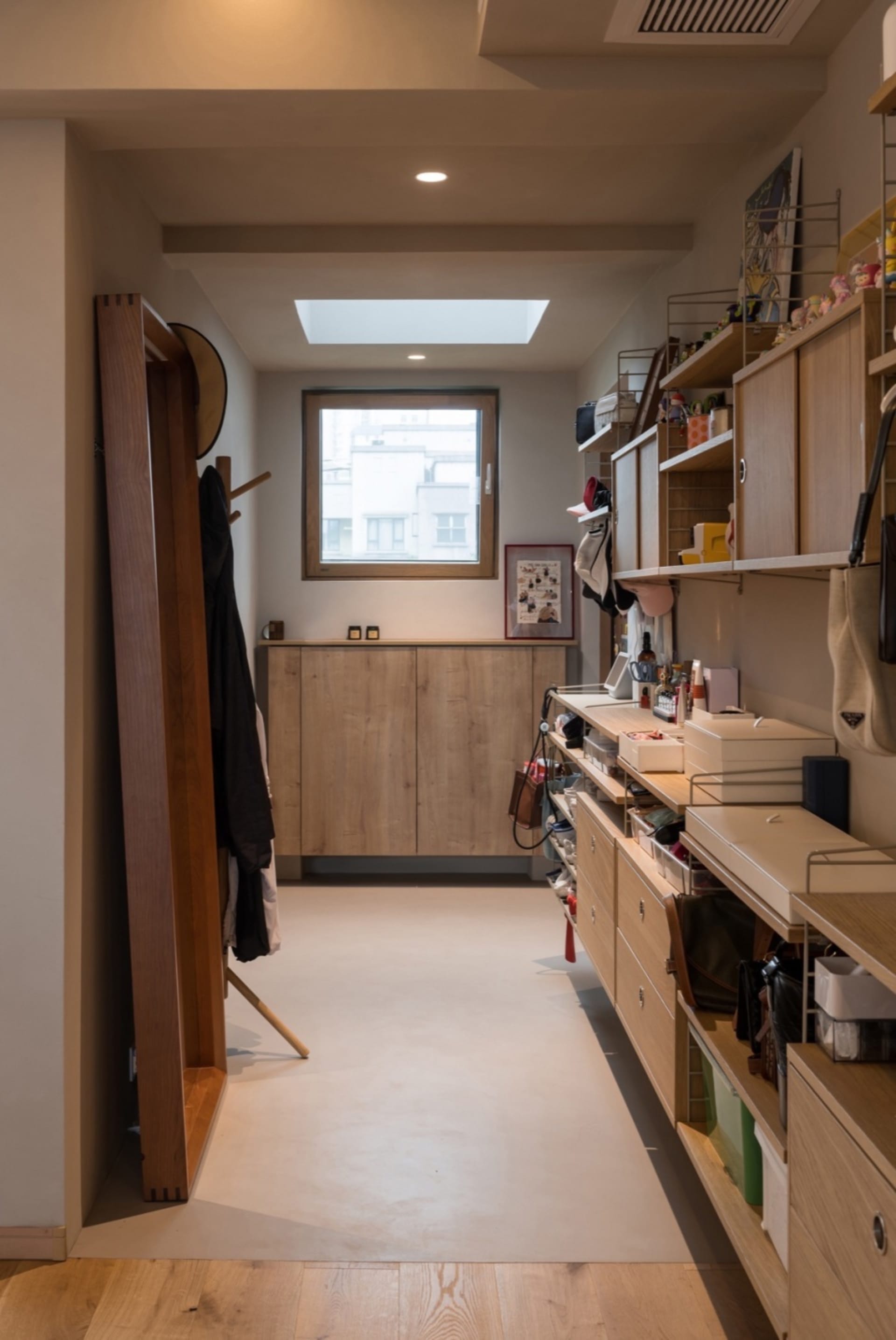 A minimalist closet with wooden shelves, cabinets, and racks.