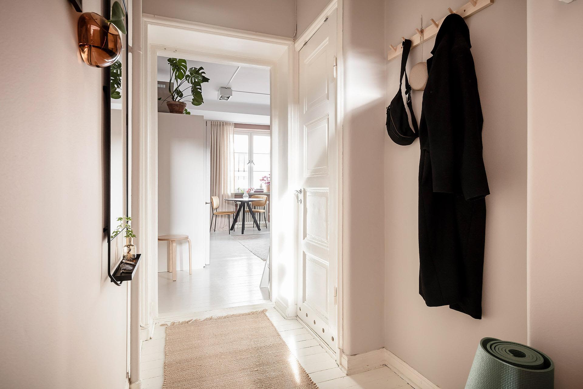 A minimalist entryway featuring neutral tones and a wooden floor.