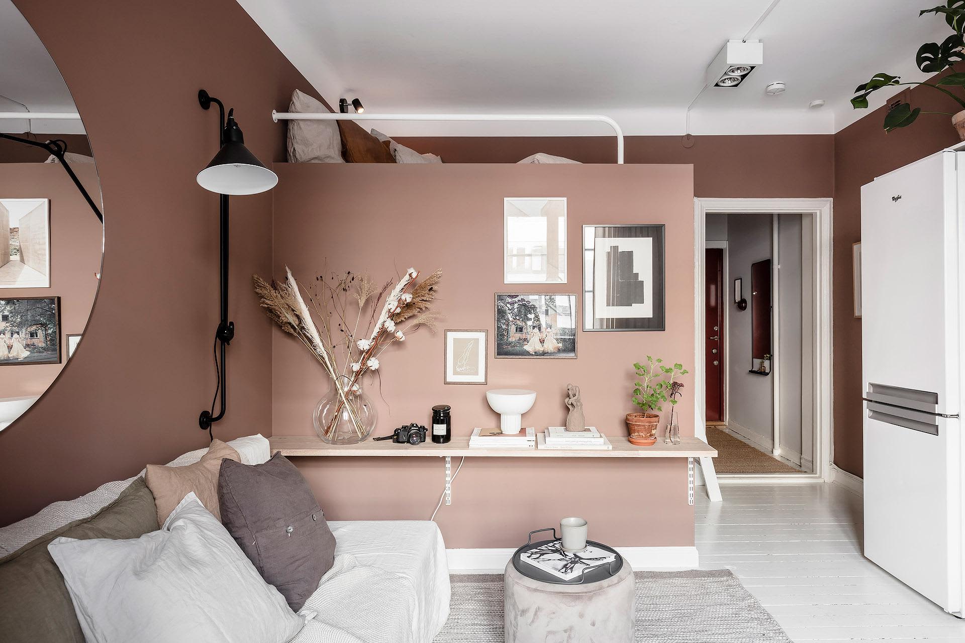 A minimalist living room with white wood finishes, featuring a white sofa adorned with white and gray pillows, a coffee table