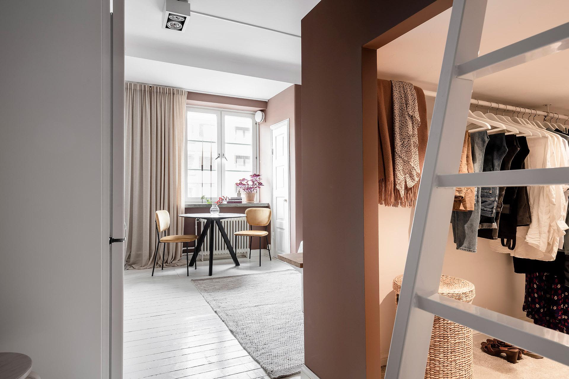 A minimalist white home office with white wooden floors, a white table, and white chairs.