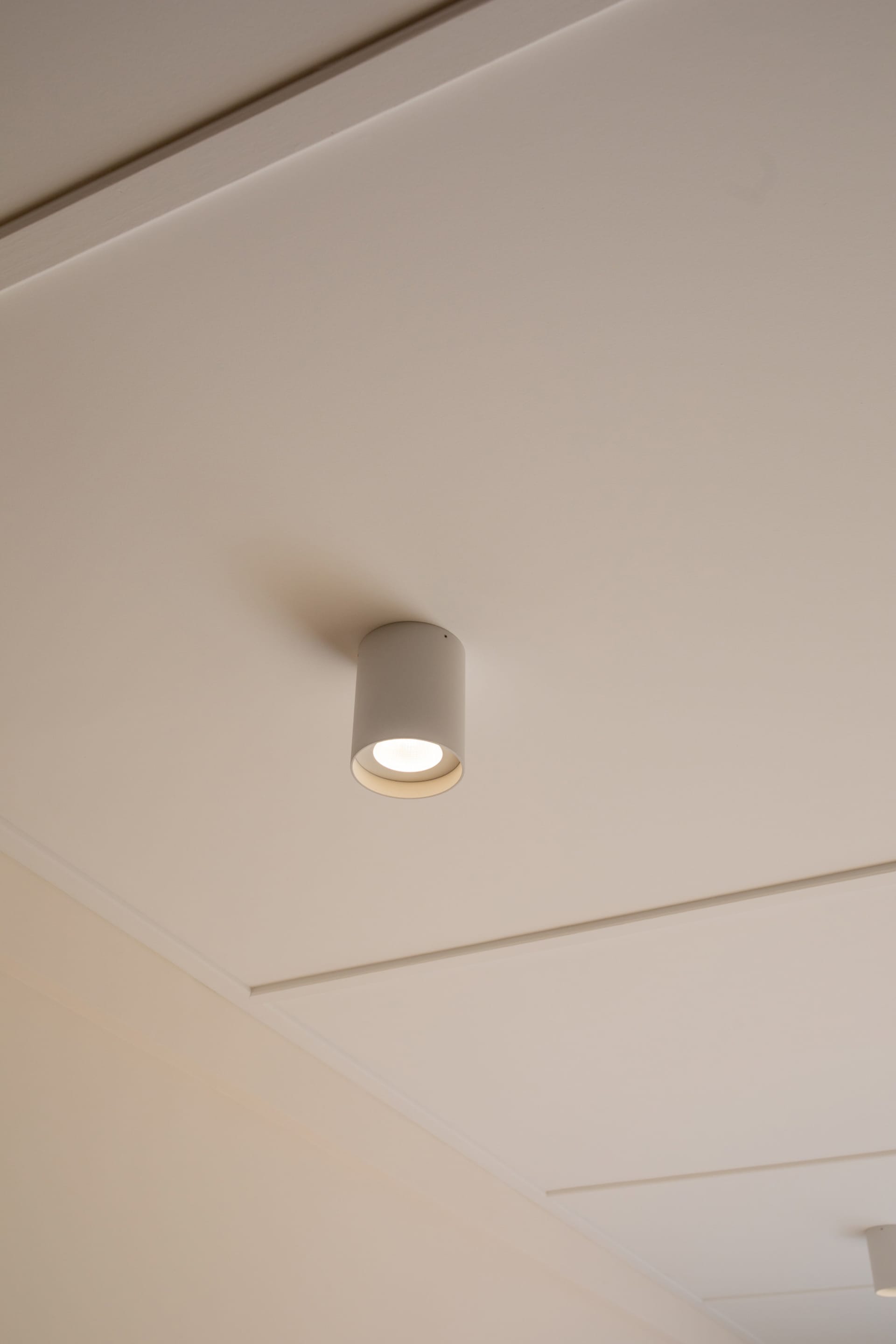 Modern minimalist ceiling light fixture on a white ceiling.