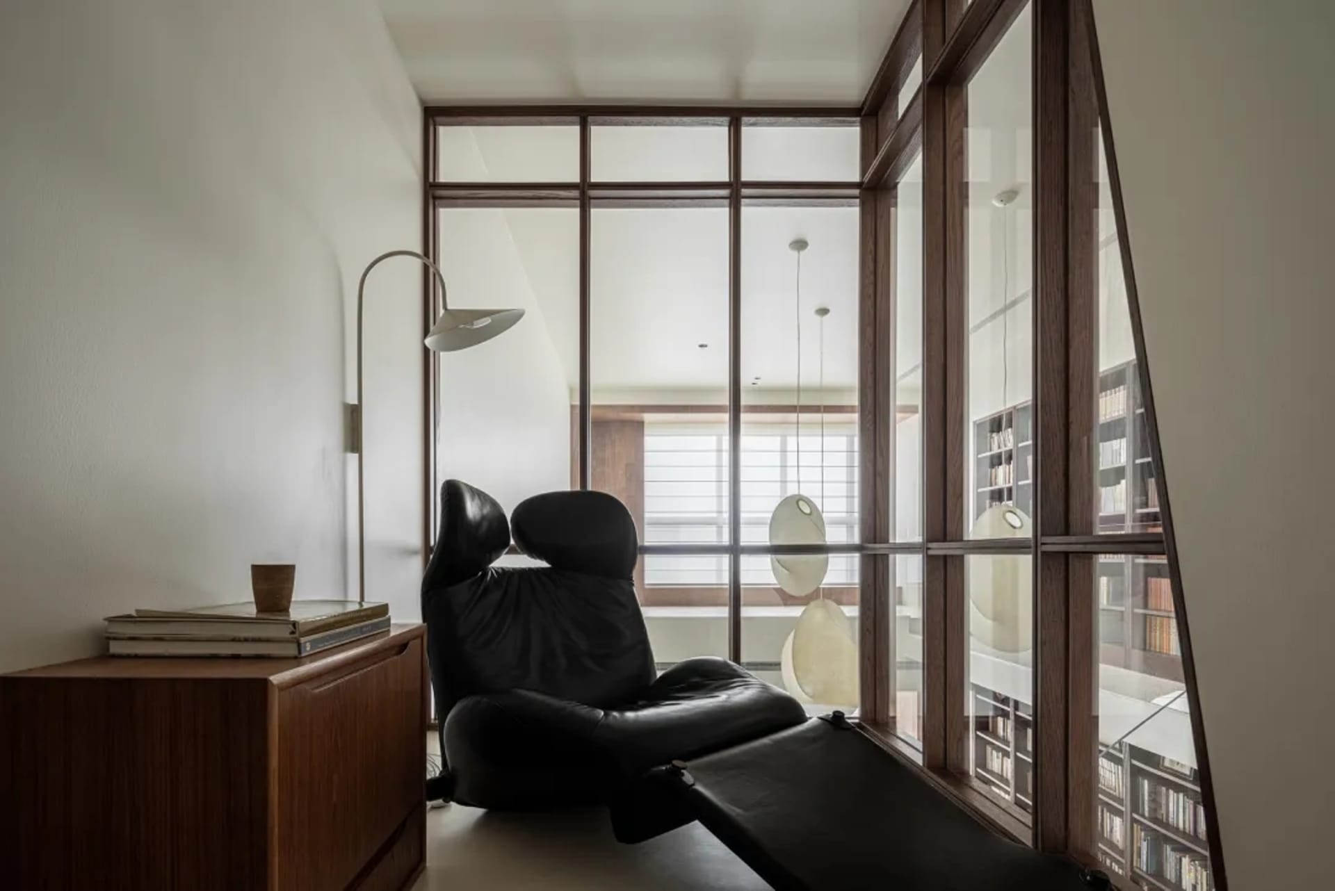 A minimalist living room with industrial design elements, featuring metal furniture and a floor lamp.