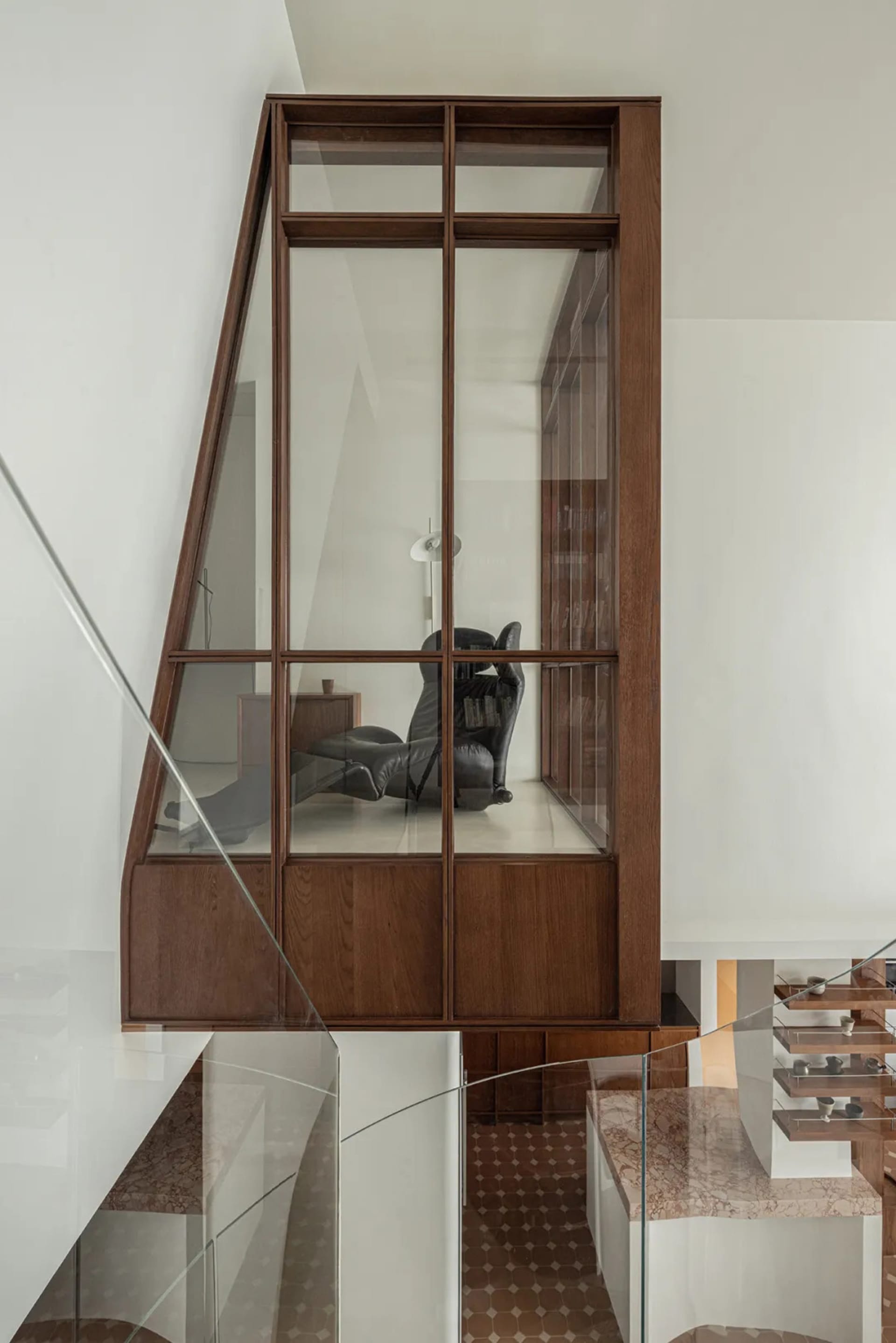 A modern interior design featuring a wooden wall with a glass window.