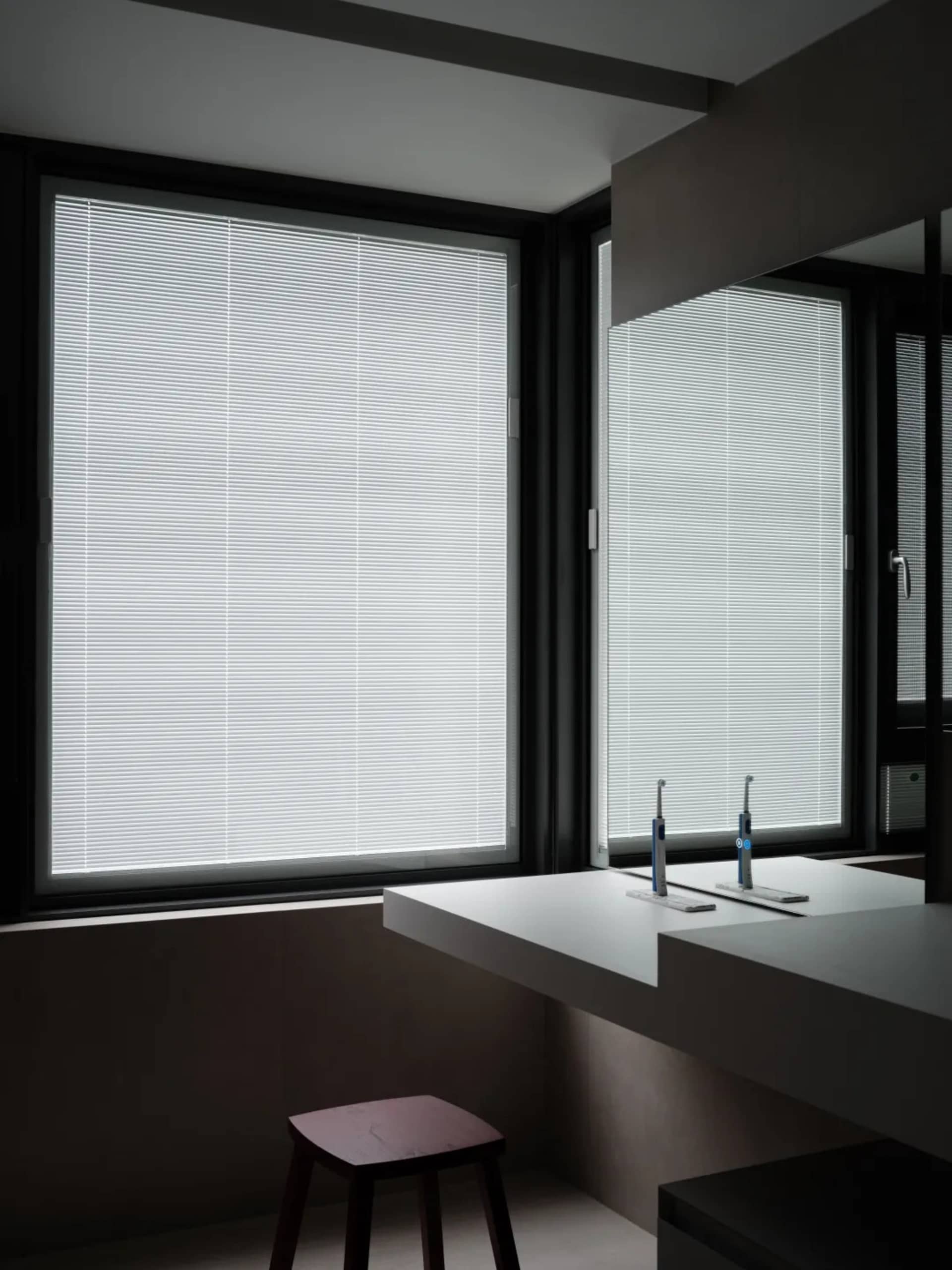 Bathroom interior featuring large windows with aluminum blinds.