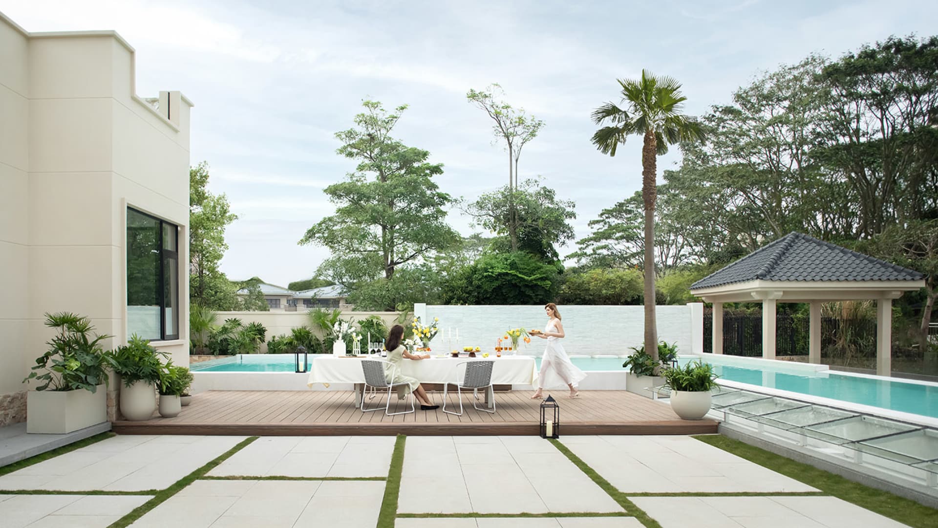 An outdoor living space featuring modern design elements with concrete, wood, metal, and glass materials.