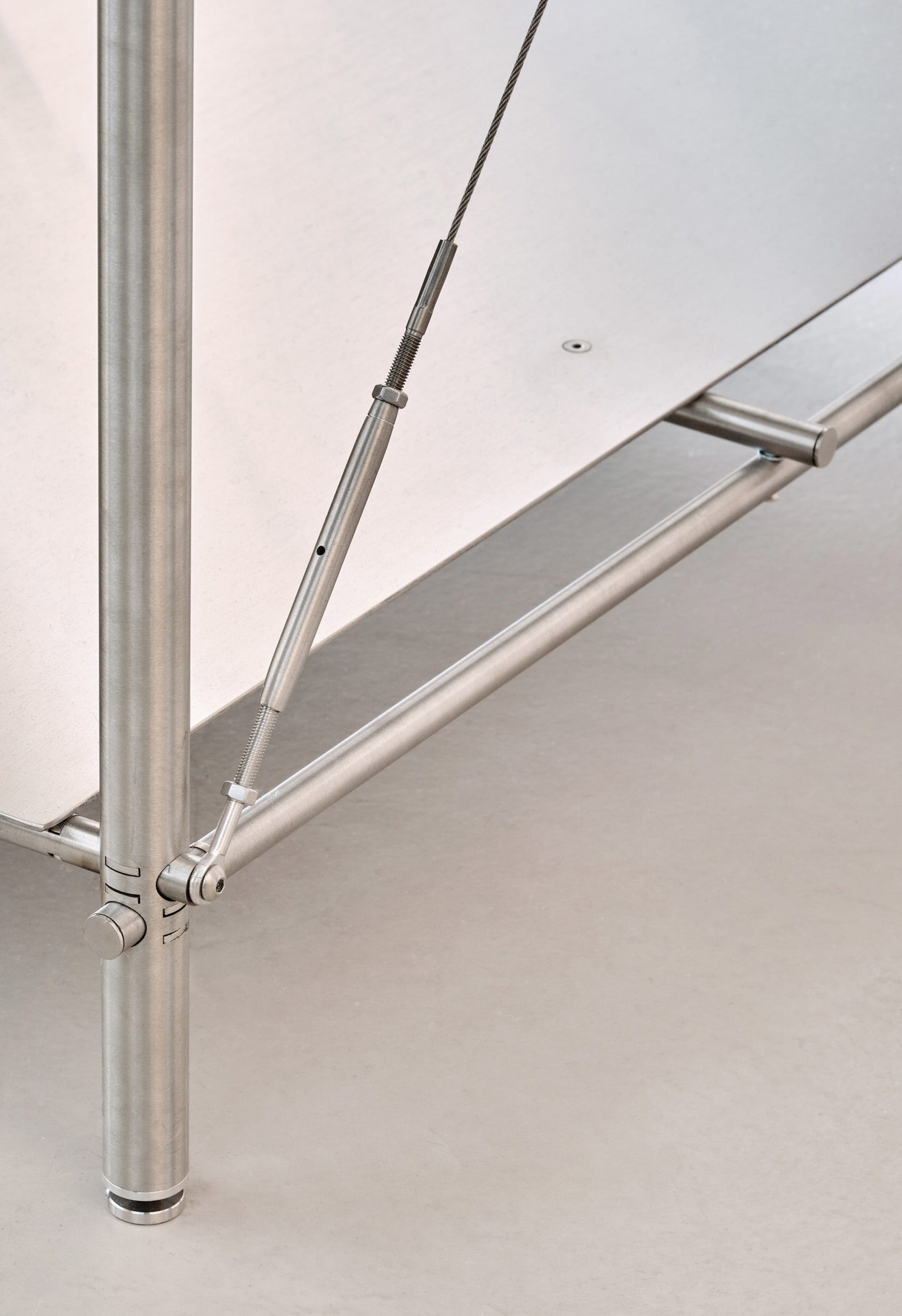 Modern metal table with structural components and cables