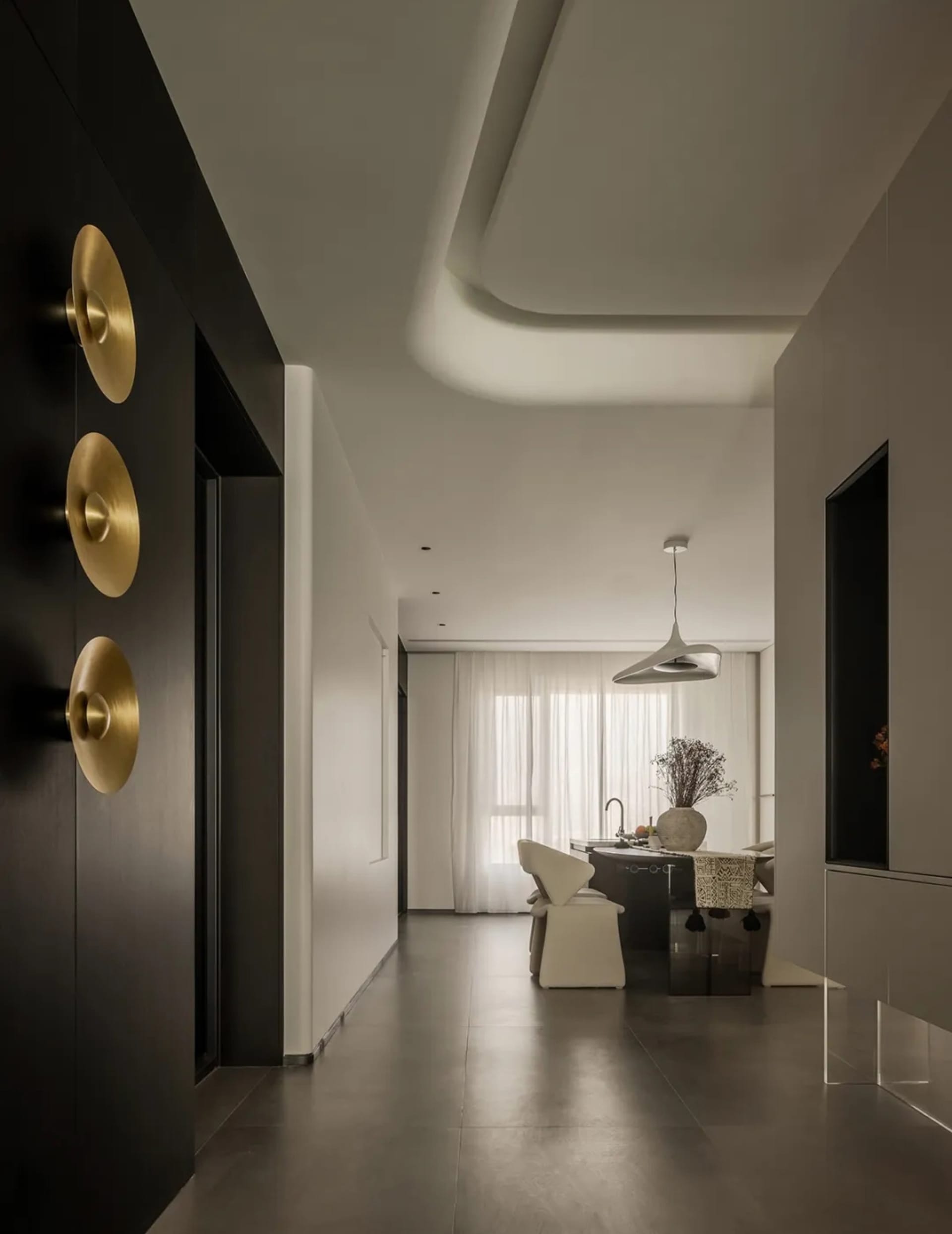 Modern minimalist living room with concrete floor and glass walls, showcasing clean lines and natural light.