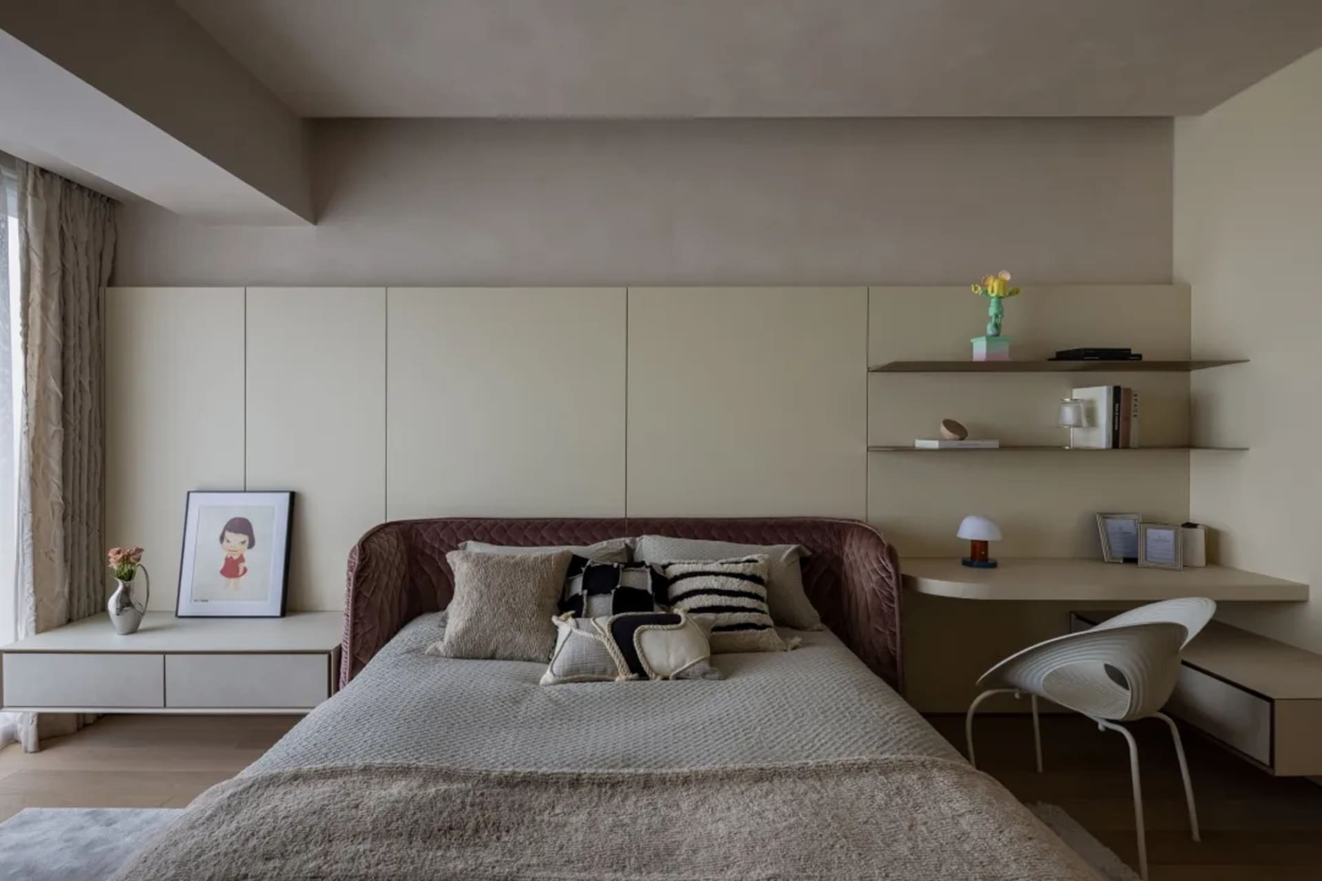 Minimalist bedroom featuring upholstered fabric bed, floating shelves, and wooden furniture.