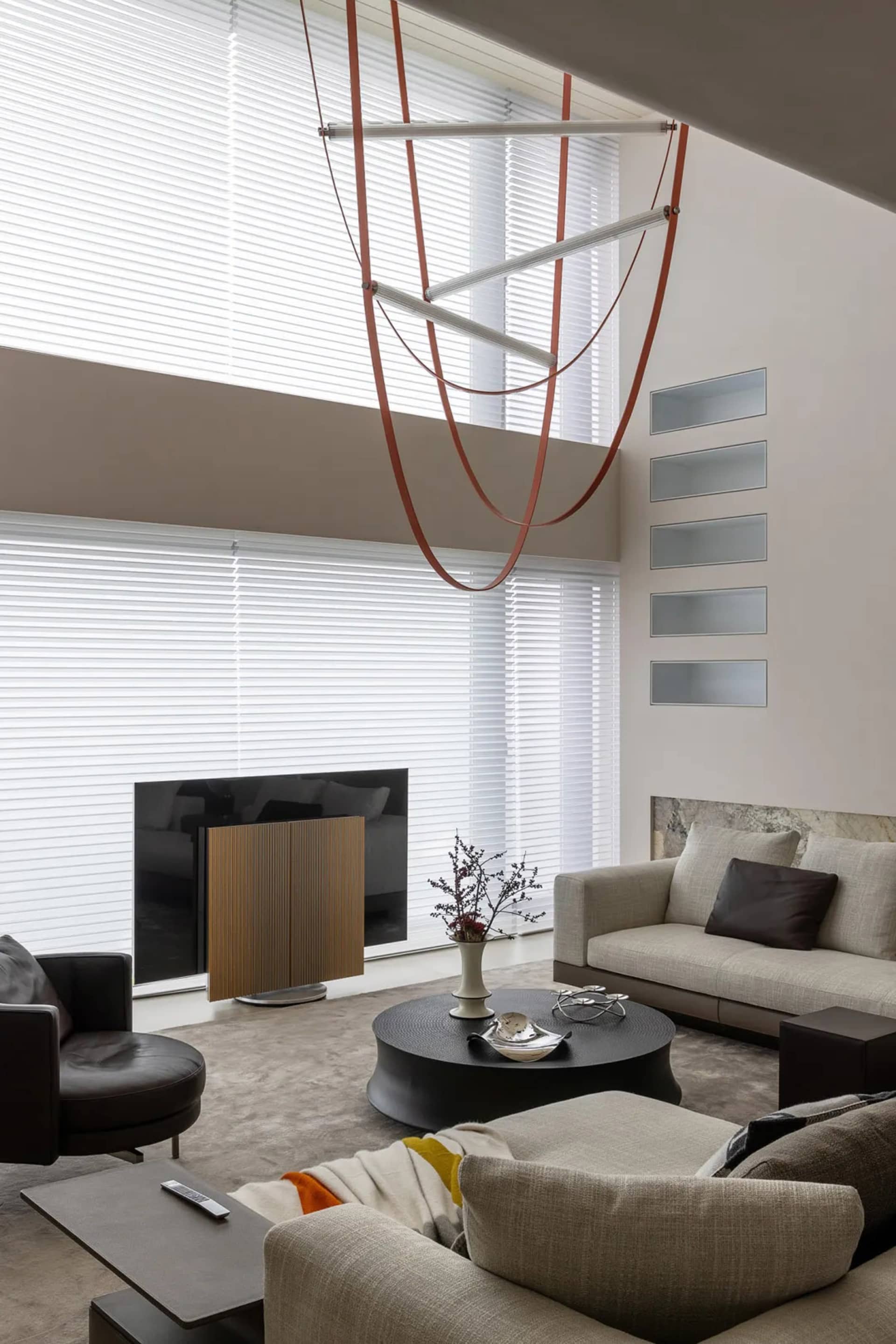 A modern living room featuring concrete elements and leather furniture.