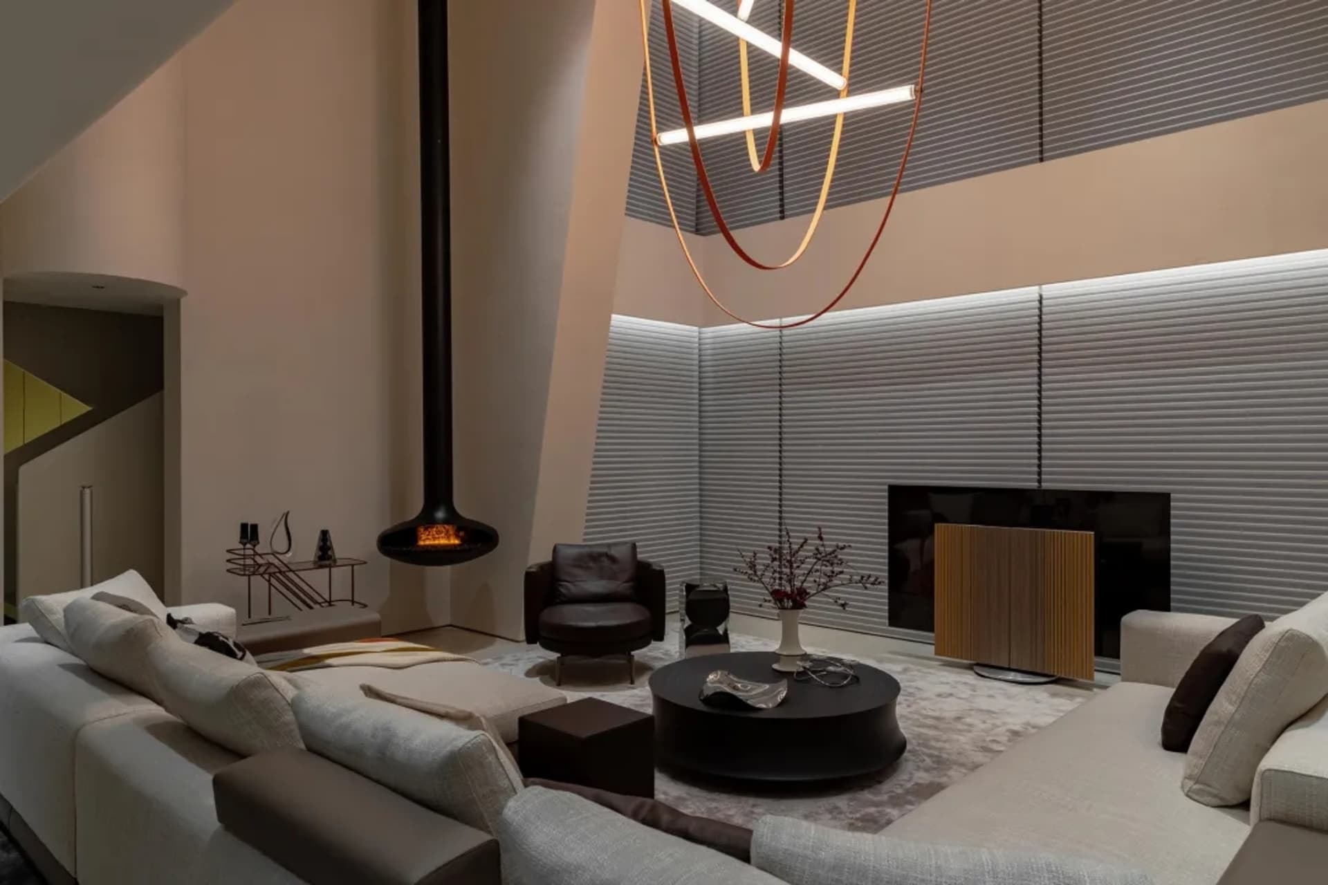 Modern living room with metallic decor, glass elements, wooden accents, and fabric furniture