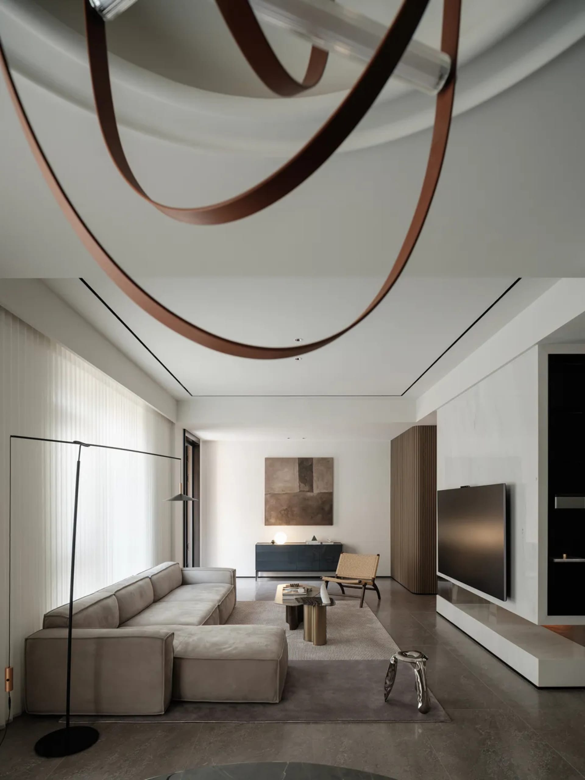 Modern minimalist living room with concrete, leather, and wood finishes