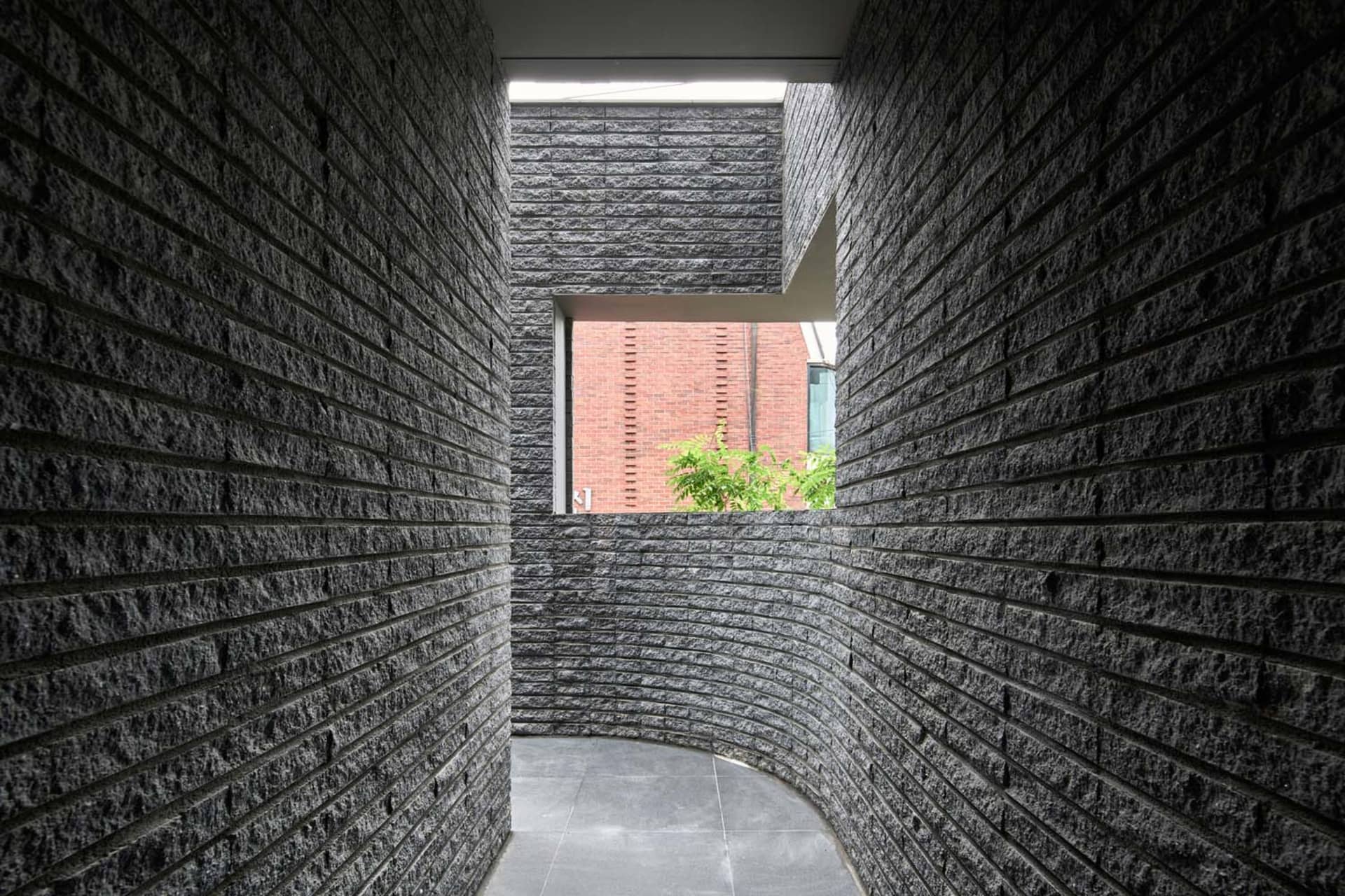 A minimalist interior space with concrete walls and a window.