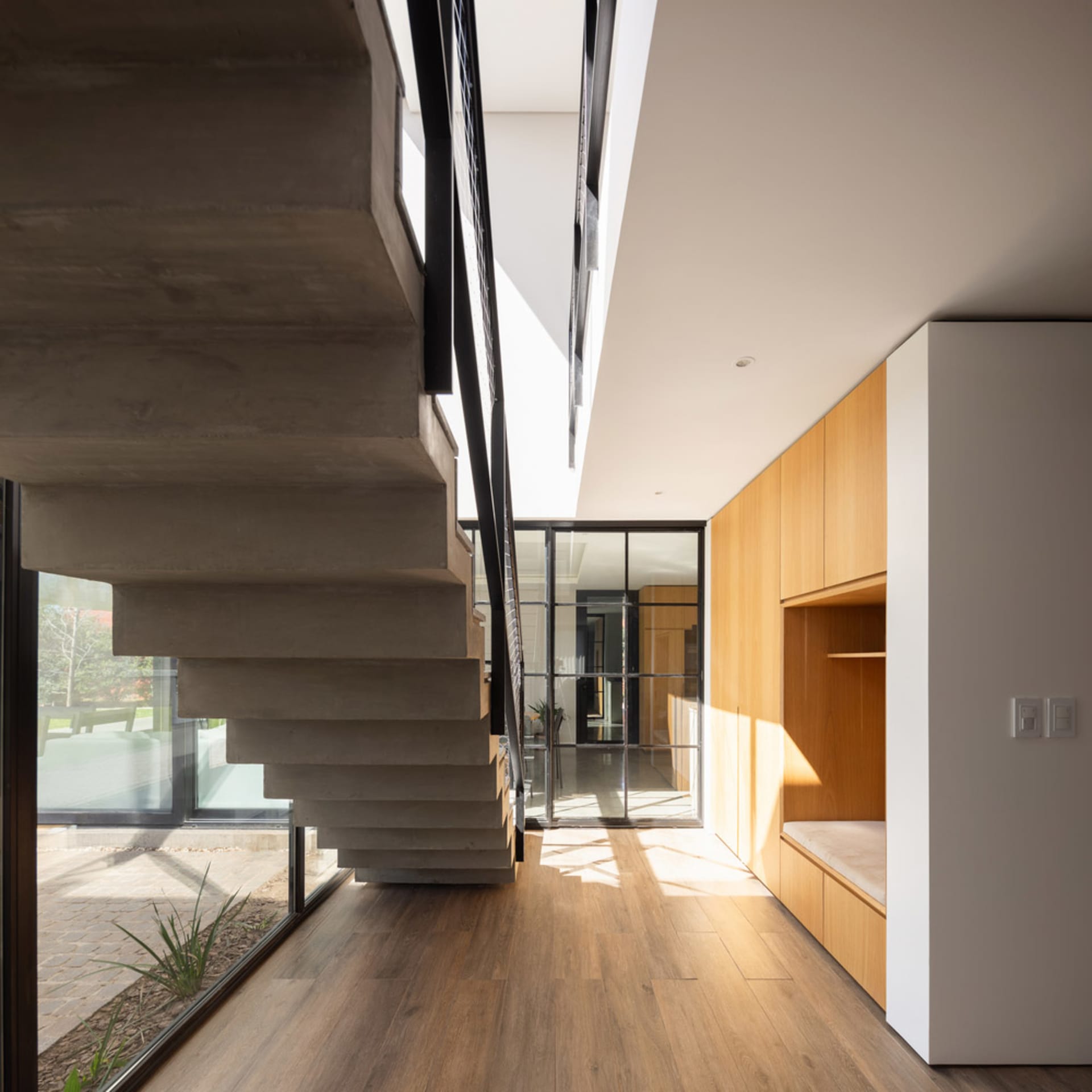 Modern concrete staircase with black metal railing.