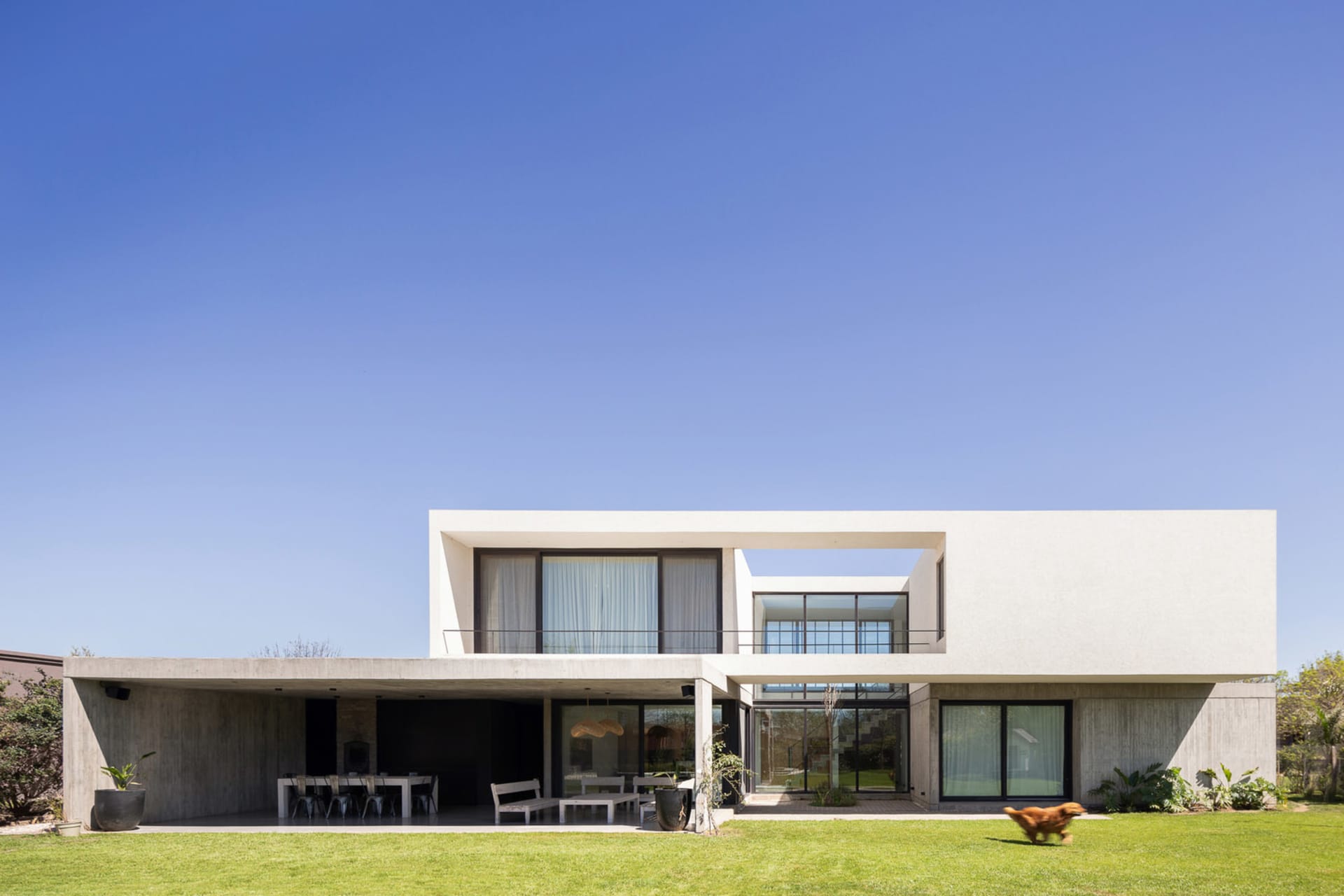 A modern residential exterior with a minimalistic, concrete and glass design.