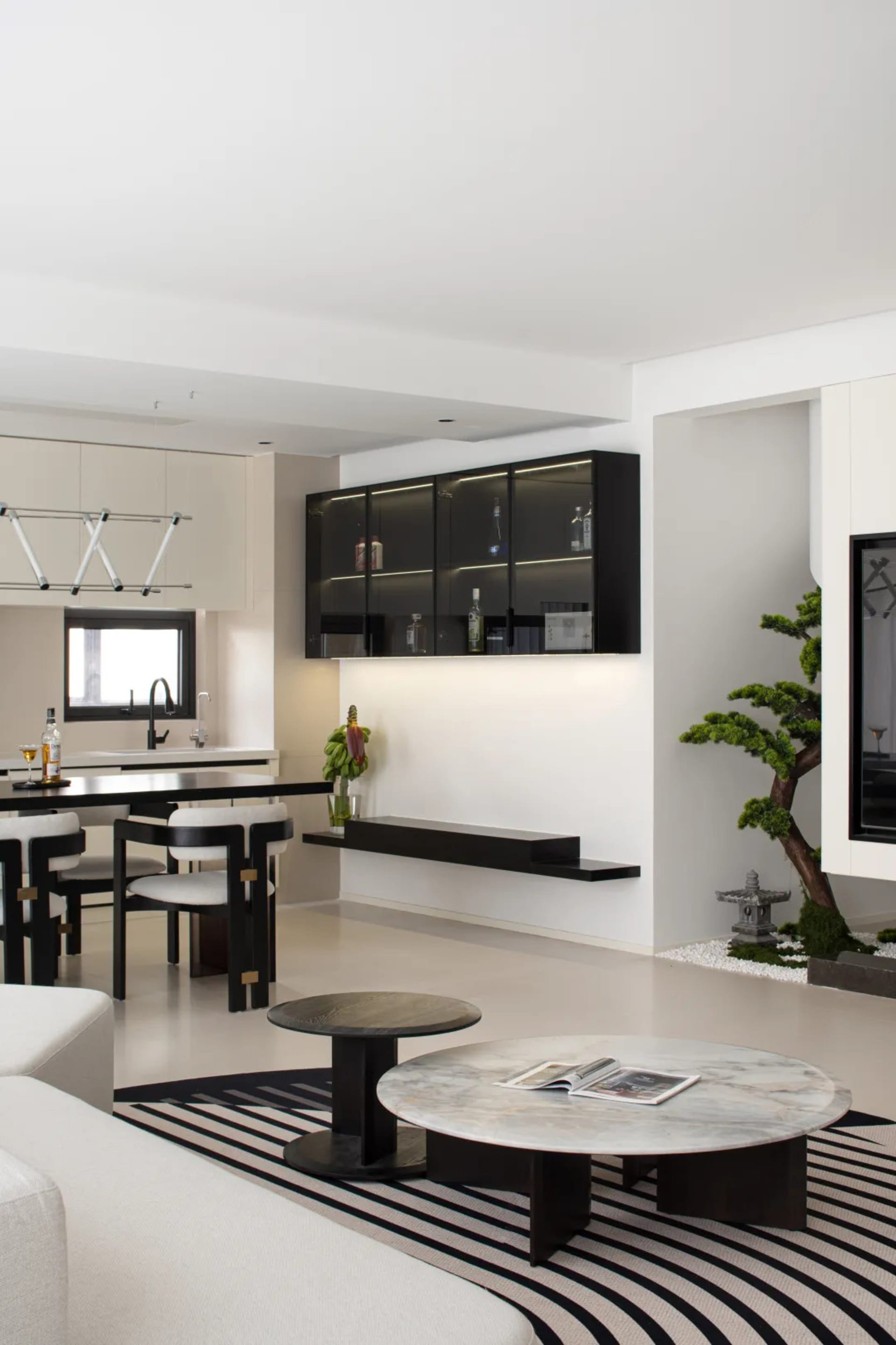 A modern living room featuring a stylish kitchen counter with minimalist black and white design.