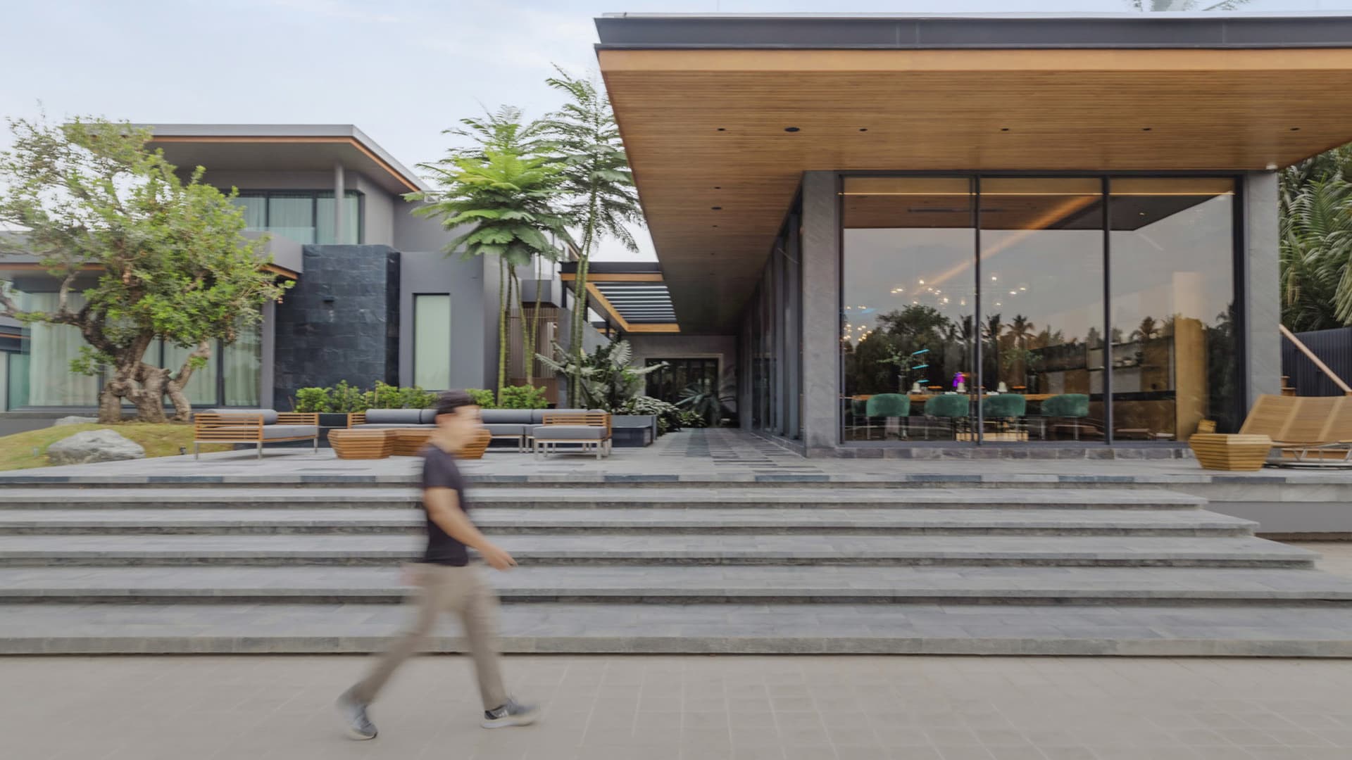Modern house exterior with concrete, glass, and wooden elements.