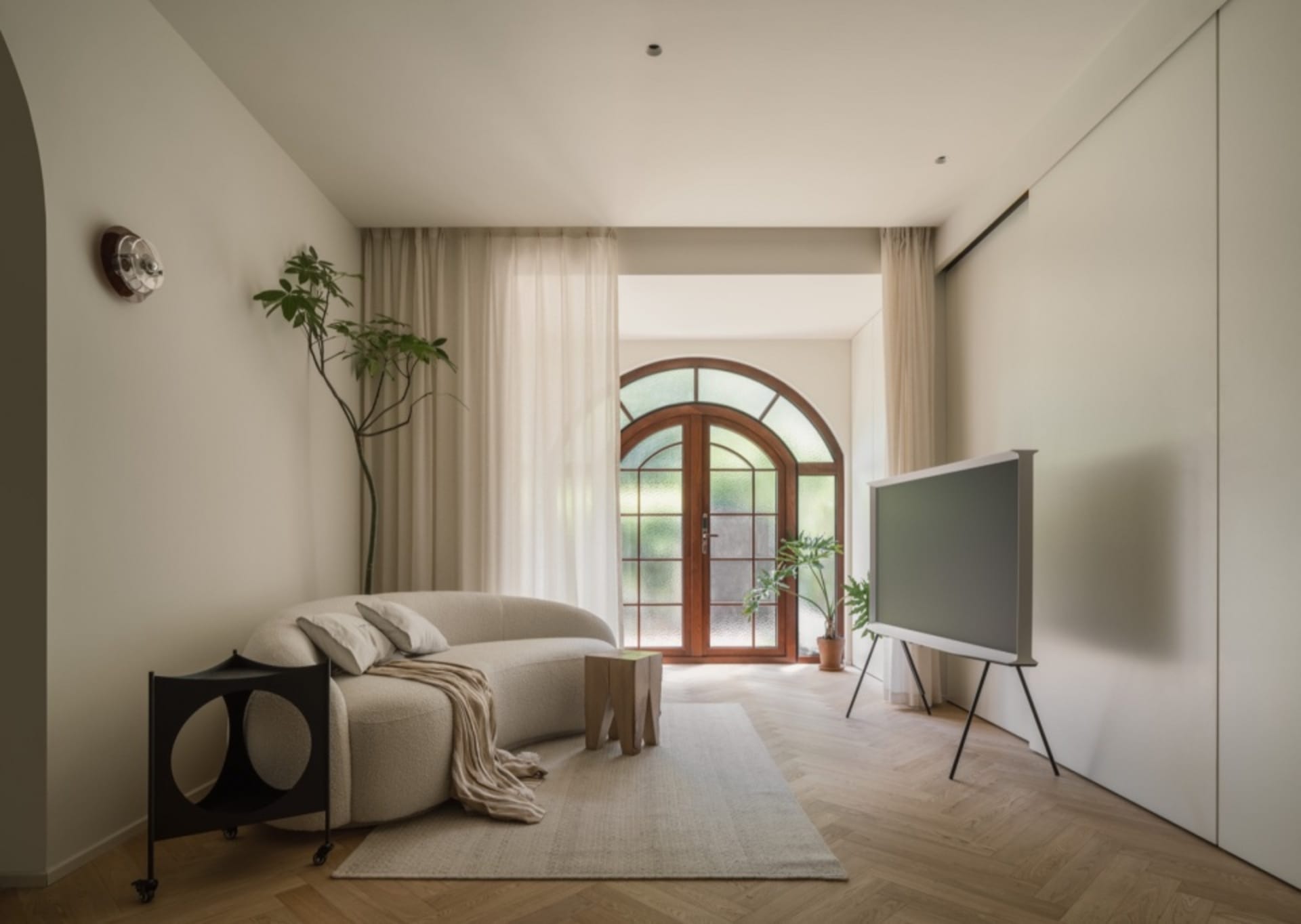 Modern living room featuring cushions, wooden furniture, and glass doors.