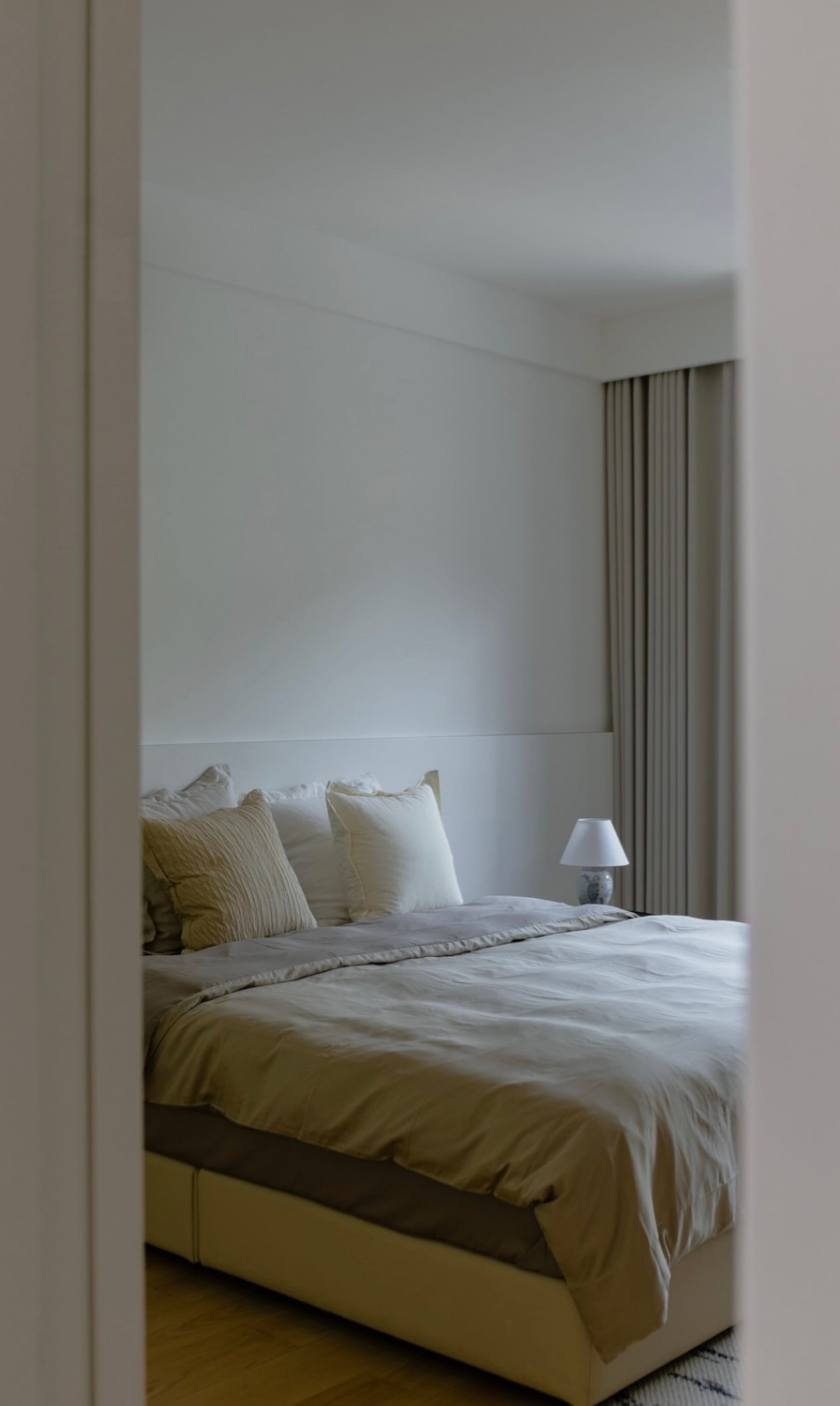 A modern bedroom with fabric bedding and minimalist decor.