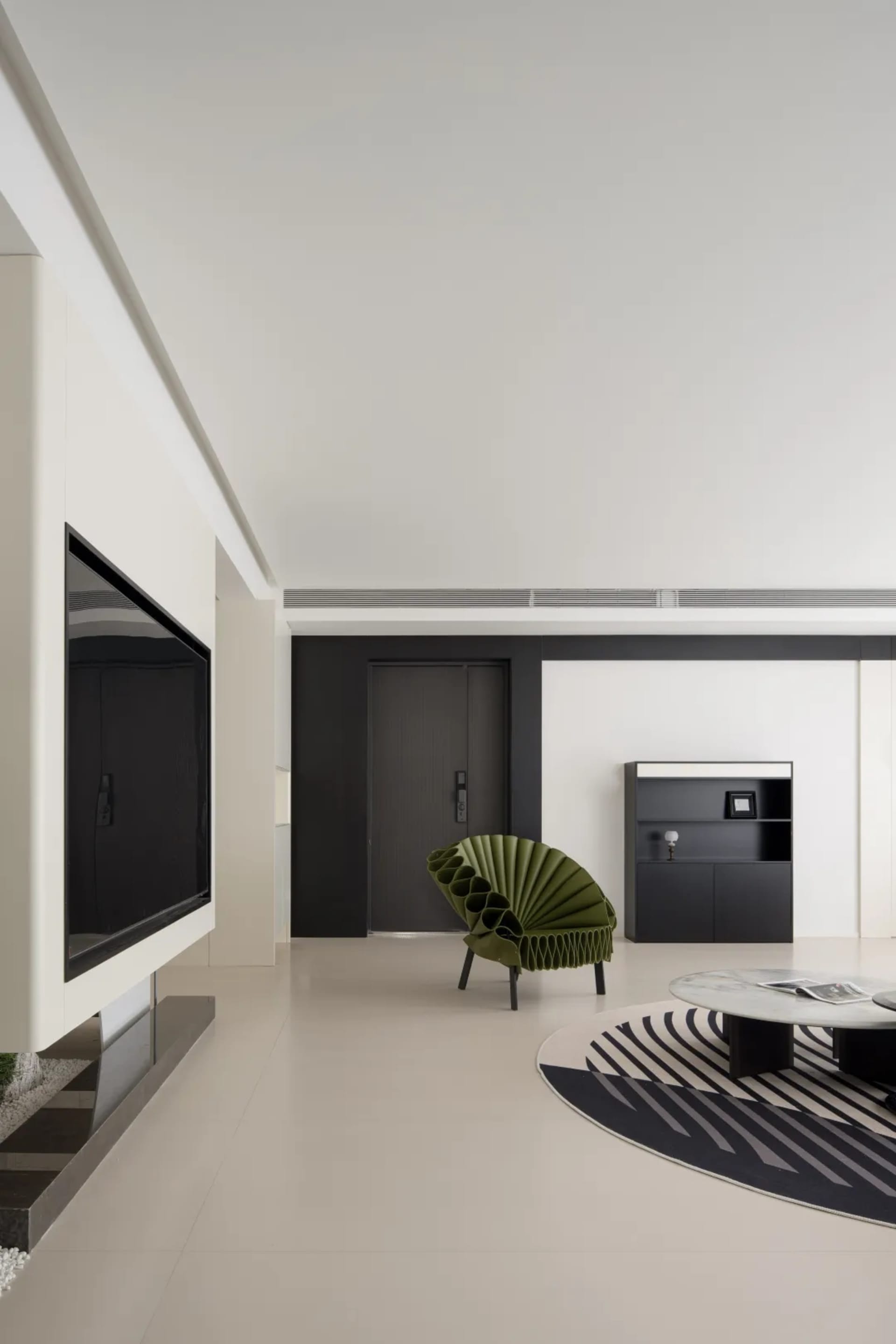 A modern living room featuring a concrete floor, minimalist furniture, and geometric patterns.