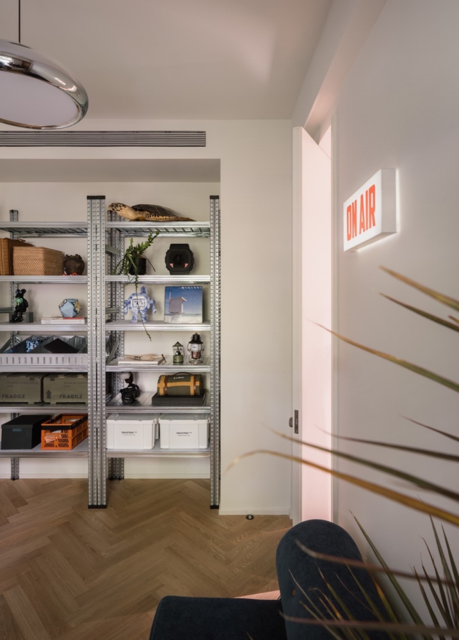 A modern living room featuring metal shelves and wooden flooring.