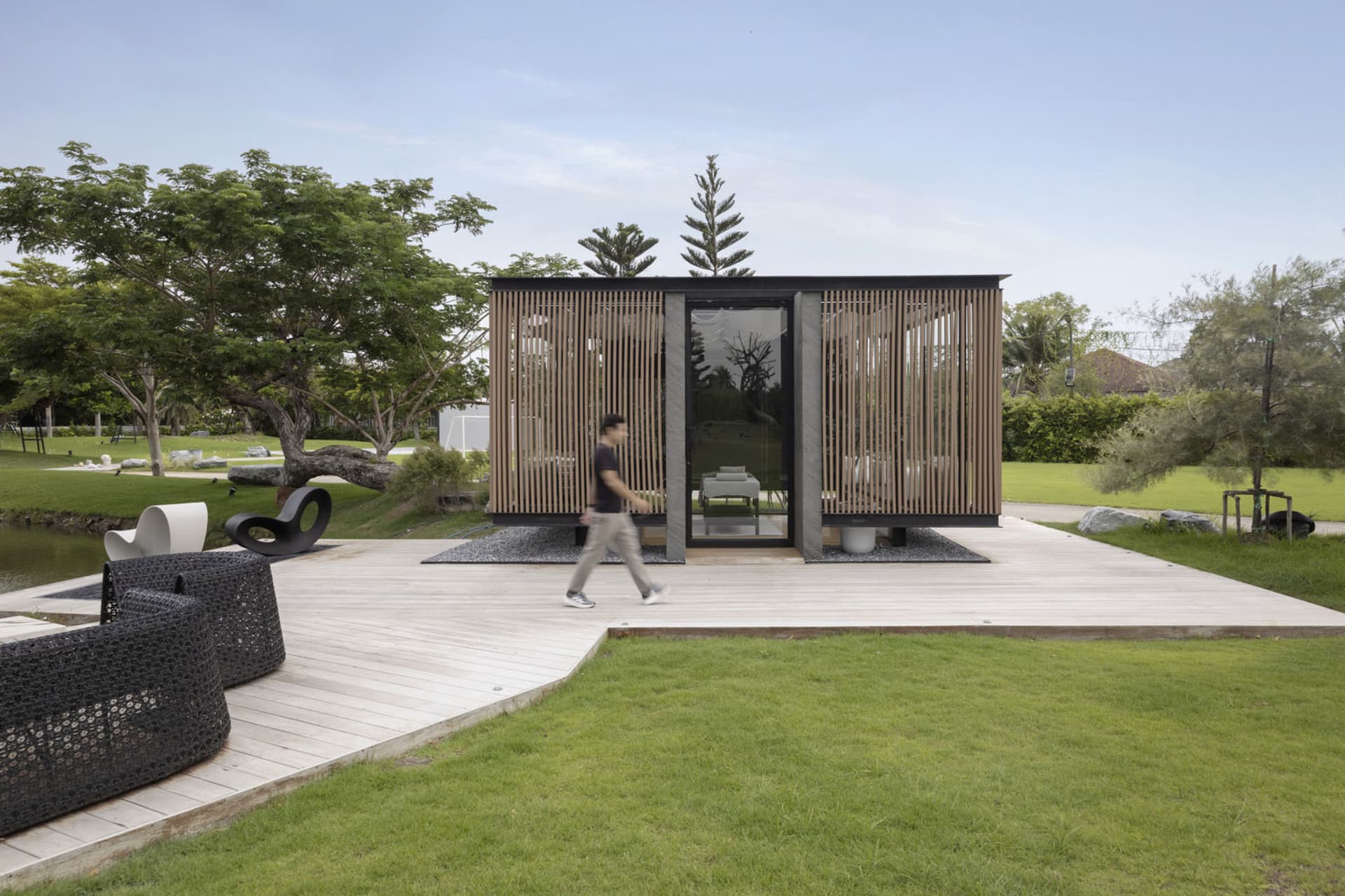 A modern minimalist pavilion with wood, glass, and stone materials